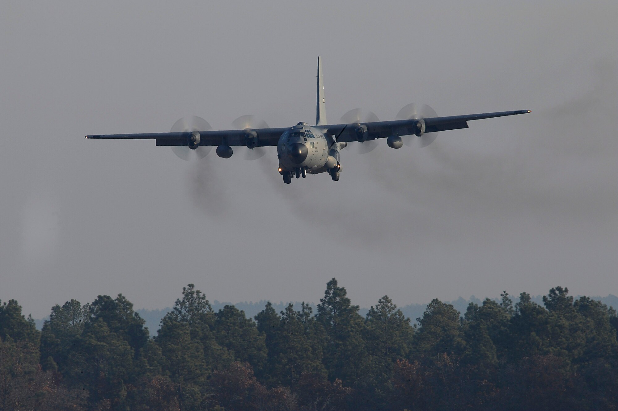 A C-130 Hercules from Pope Air Force Base, N.C., prepares to land at Drop Zone Sicily to pick up Army Soldiers from the 82nd Airborne Division at Fort Bragg, N.C., for a parachute jump Dec. 6 during Operation Toy Drop at Fort Bragg. Operation Toy Drop is an annual Airborne jump at Fort Bragg in its 11th year hosted by the Army Civil Affairs and Psychological Operations Command (Airborne), and supported by Fort Bragg's XVIII Airborne Corps and the Air Force Reserve Command's 440th Airlift Wing at Pope AFB that gives Soldiers and Airmen the opportunity to help local families in need over the holidays while boosting morale and incorporating valuable training. More than 3,000 Soldiers donated a toy for a lottery ticket and the chance to jump under a foreign jumpmaster, earning them their foreign jump wings. This year, German and Irish jumpmasters will be issuing the commands from C-130 Hercules aircraft during the operation. (U.S. Air Force photo/Tech. Sgt. Jeremy Lock) 
