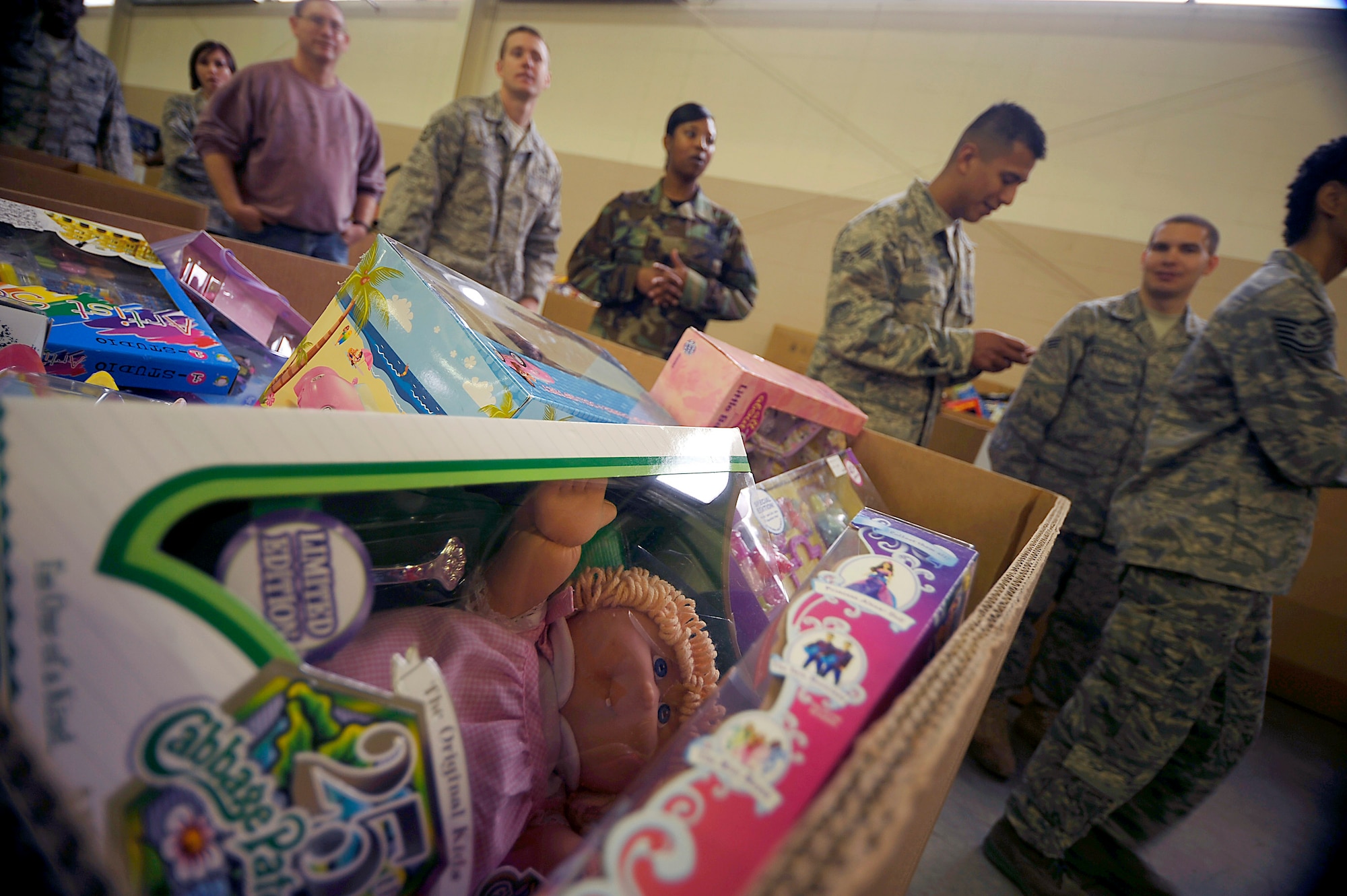 Airmen and Soldiers from Fort Bragg, N.C., collect and sort toys donated Dec. 5 during Operation Toy Drop at Pope Air Force Base, N.C. Operation Toy Drop is an annual Airborne jump at Fort Bragg in its 11th year hosted by the Army Civil Affairs and Psychological Operations Command (Airborne), and supported by Fort Braggs XVIII Airborne Corps and Pope AFB's 43rd Airlift Wing that gives Soldiers and Airmen the opportunity to help local families in need over the holidays while boosting morale and incorporating valuable training. More than 3,000 Soldiers donated a toy for a lottery ticket and the chance to jump under a foreign jumpmaster earning them their foreign jump wings. This year, German and Irish jumpmasters will be issuing the commands from C-130 Hercules aircraft during the operation. (U.S. Air Force photo/Tech. Sgt. Jeremy Lock) 
