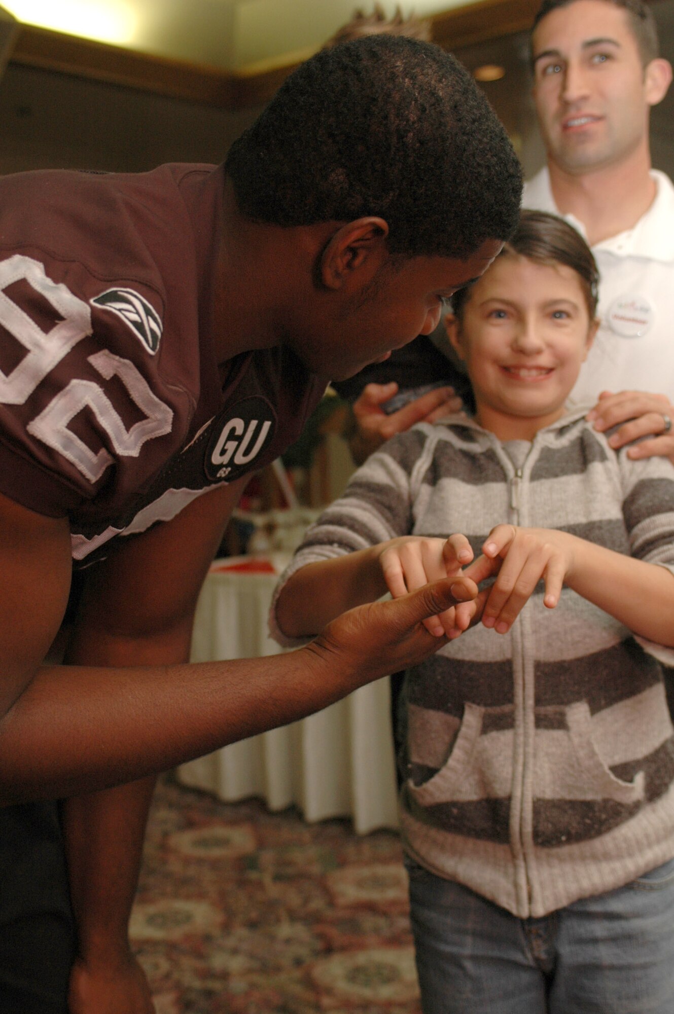 Stacia Torres, 12, meets Derrick Gray from the Oakland Raiders at this year’s Special Needs Holiday Party Dec. 9 at the Travis Conference Center. Mr. Gray took photos with party guests and talked about being a football player in the National Football League. (U.S. Air Force photo/Staff Sgt. Shaun Emery)