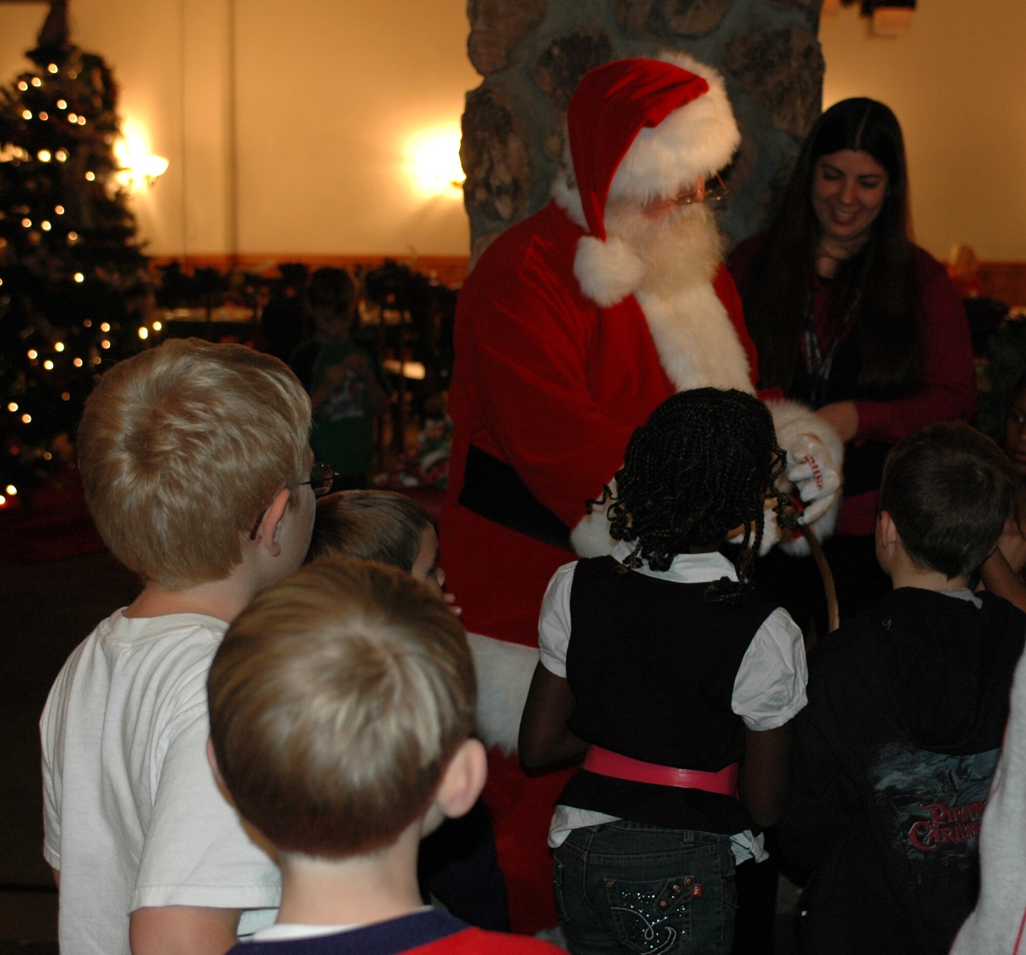 Santa hands out candy canes to children during the Deployed Spouses Dinner Dec. 8 at the Travis Conference Center. The event gave the spouses and children of those deployed a chance to socialize with other families, hear from base leadership and learn about a variety resources to assist them while their spouse is deployed. (U.S. Air Force photo/Airman 1st Class Kristen Rohrer)