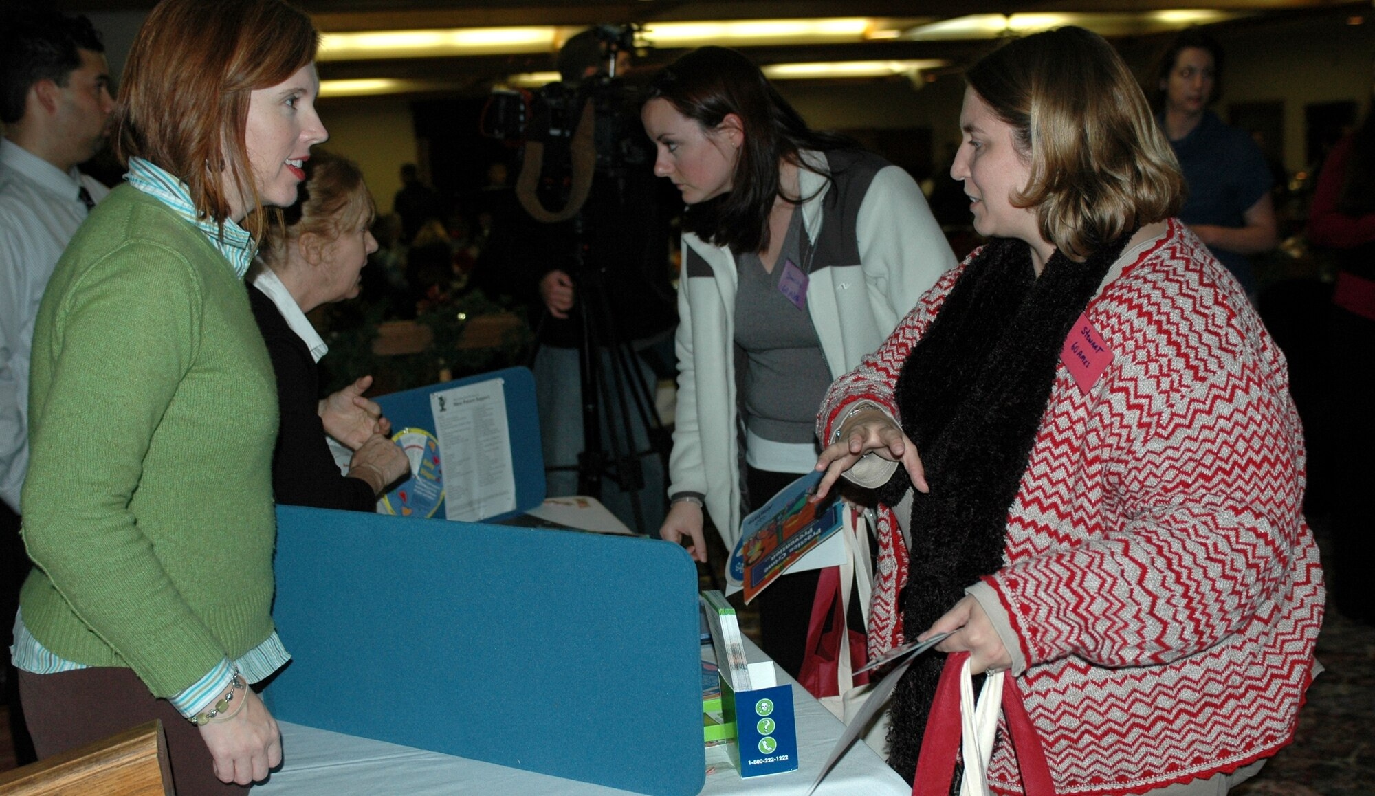 Representatives from Family Advocacy speak to several spouses during the Deployed Spouses Dinner Dec. 8 at the Travis Conference Center.  The event gave the spouses and children of those deployed a chance to socialize with other families, hear from base leadership and learn about a variety resources to assist them while their spouse is deployed. (U.S. Air Force photo/Airman 1st Class Kristen Rohrer)