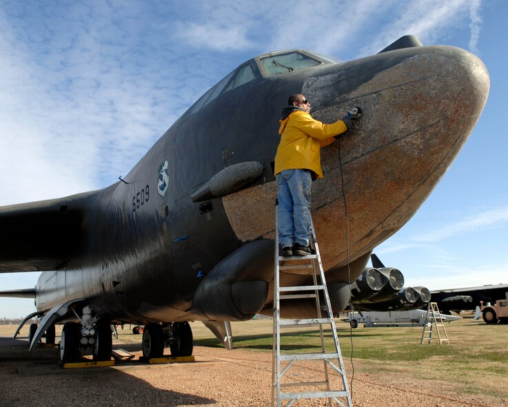A volunteer removes the paint from the exterior of a Boeing B-52 at the 8th Air Force Museum Airpark located on Barksdale Air Force Base, La., Dec. 5. The maintenance marks the beginning of the renovation to the outside of the bomber. (U.S. photo by Airman 1st Class Brittany Y. Bateman)
