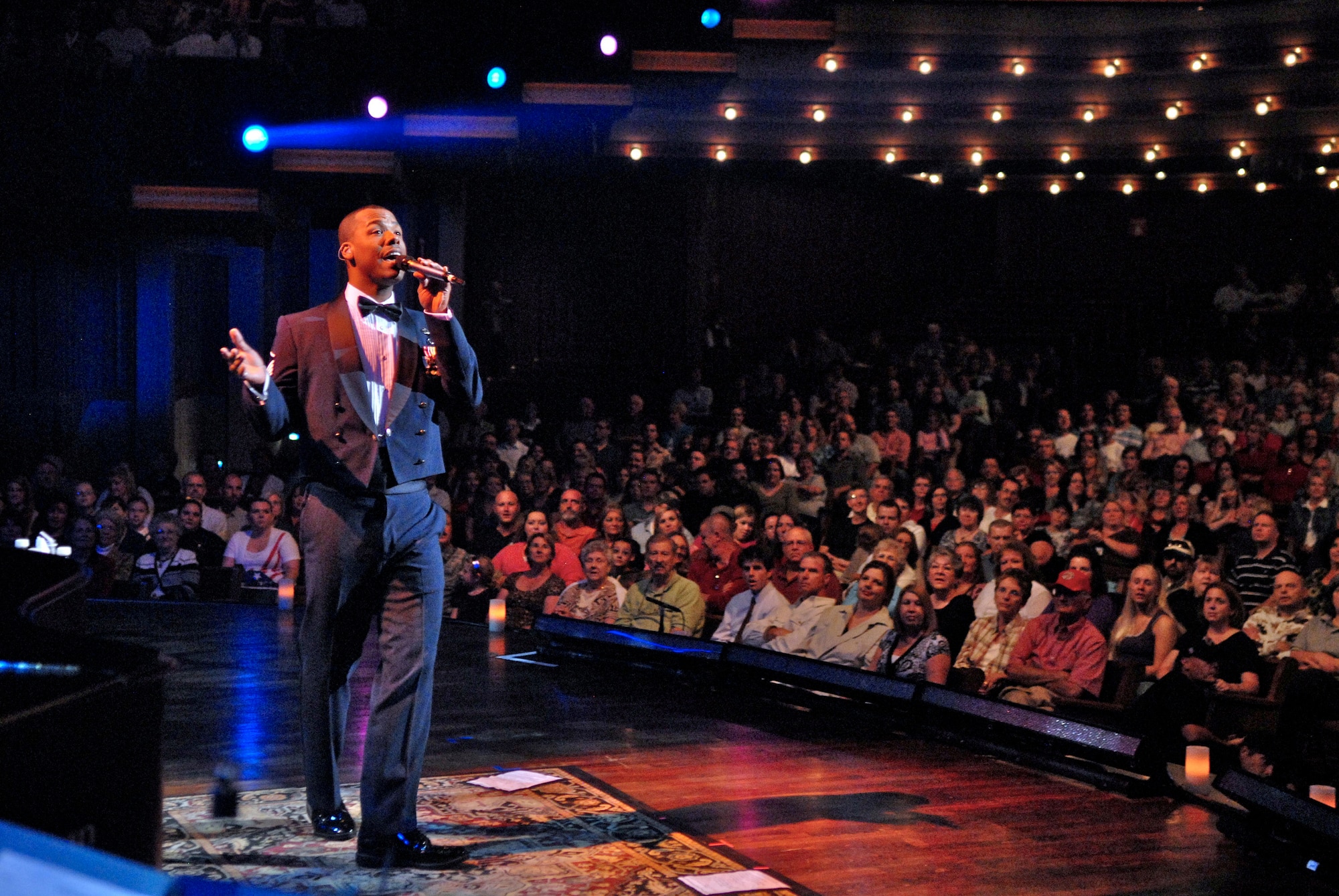Master Sgt. Aaron Miles sings classic holiday songs to the audience during the 2008 Holiday Notes from Home concert recorded Dec. 9 in Nashville, Tenn. The concert is an annual holiday event recorded at the Grand Ole Opry House as a tribute to military men and women serving around the world. The show airs on Great American Country and on American Forces Network channels throughout December. Sergeant Miles is a Band of the Air Force Reserve vocalist. (U.S. Air Force photo/Ken Hackman) 
