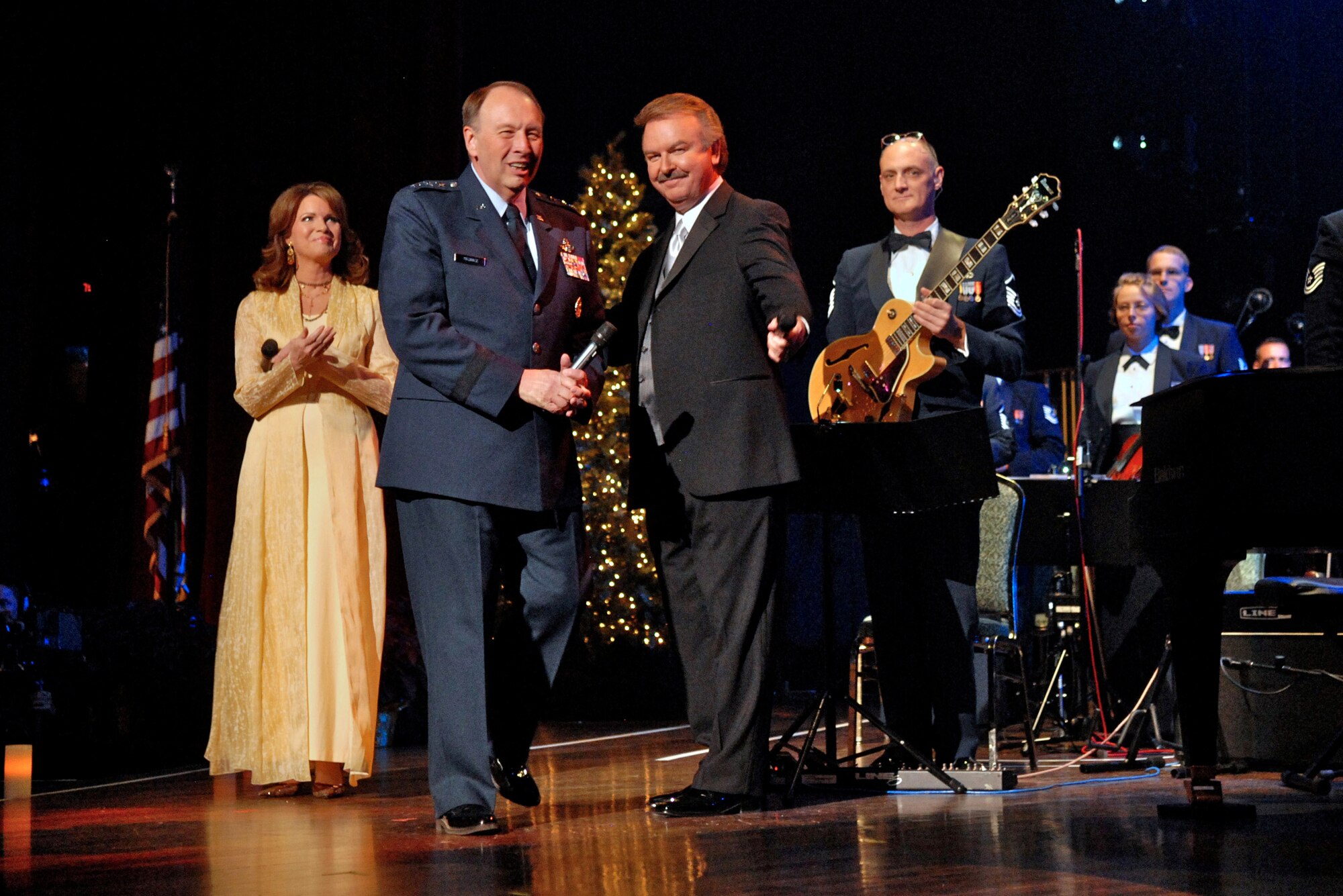 Lt. Gen. Charles E. Stenner Jr. is received by hosts Lorrain Crook and Charlie Chase during the Holiday Notes from Home concert recorded Dec. 9 in Nashville, Tenn. The concert is annual holiday event recorded at the Grand Ole Opry House as a tribute to military men and women serving around the world. The show airs on Great American Country and on American Forces Network channels throughout December. General Stenner is the commander of the Air Force Reserve Command. (U.S. Air Force photo/Ken Hackman) 
