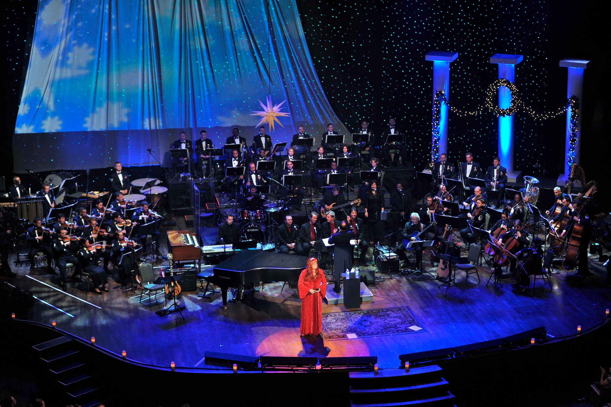 Wynonna Judd sings classic holiday music while the Band of the Air Force Reserve and Air Force Strings perform in the background during the 2008 Holiday Notes from Home concert recorded Dec. 9 in Nashville, Tenn. The concert is annual holiday event recorded at the Grand Ole Opry House as a tribute to military men and women serving around the world. The show airs on Great American Country and on American Forces Network channels throughout December. (U.S. Air Force photo/Ken Hackman) 
