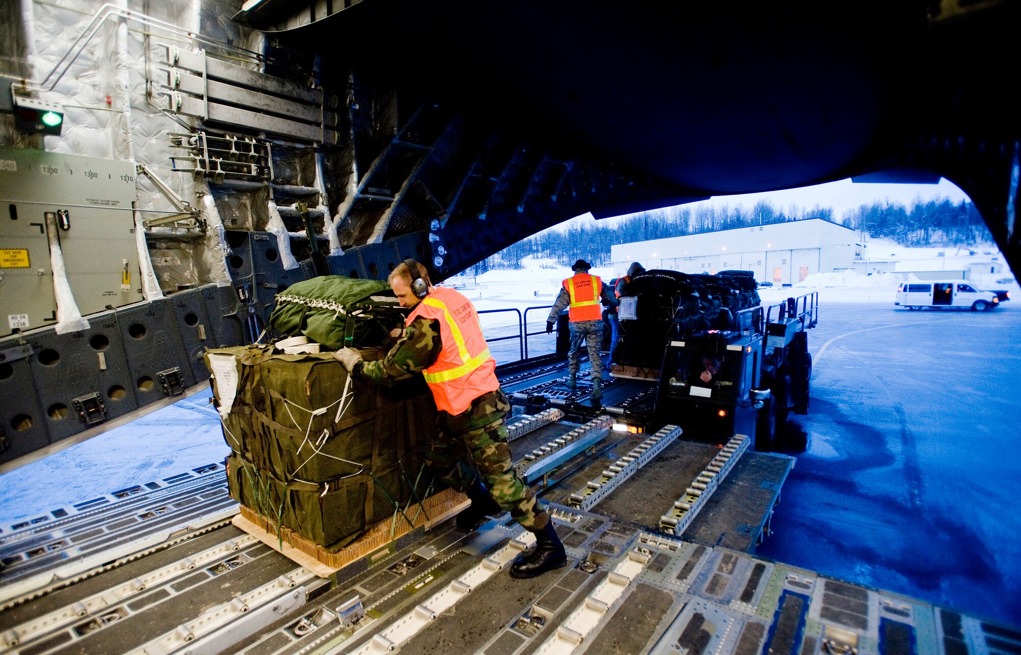 ELMENDORF AIR FORCE BASE, Alaska -- Tech. Sgt. Christopher Dye, 732nd Air Mobility Squadron, pushes Container Delivery System onto a C-17 prior to flight Dec. 9. The 4th Brigade Combat Team, 25th Infantry Division partnered with the 517th Airlift Squadron is using this week practice jumps prior to the deployment. Roughly 1,300 4-25 Soldiers will be jumping out of C-17 Globemaster IIIs during the week. (U.S. Air Force photo/Senior Airman Jonathan Steffen)