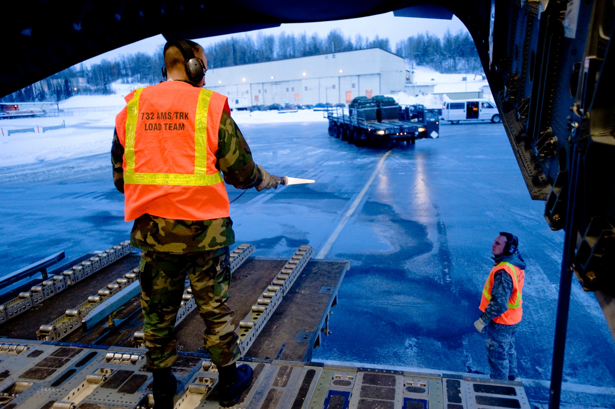 ELMENDORF AIR FORCE BASE, Alaska -- Tech. Sgt. Christopher Dye, 732nd Air Mobility Squadron, guides a k-loader full Container Delivery System away from C-17 prior to flight Dec. 9. The 4th Brigade Combat Team, 25th Infantry Division partnered with the 517th Airlift Squadron is using this week practice jumps prior to the deployment. Roughly 1,300 4-25 Soldiers will be jumping out of C-17 Globemaster IIIs during the week. (U.S. Air Force photo/Senior Airman Jonathan Steffen)