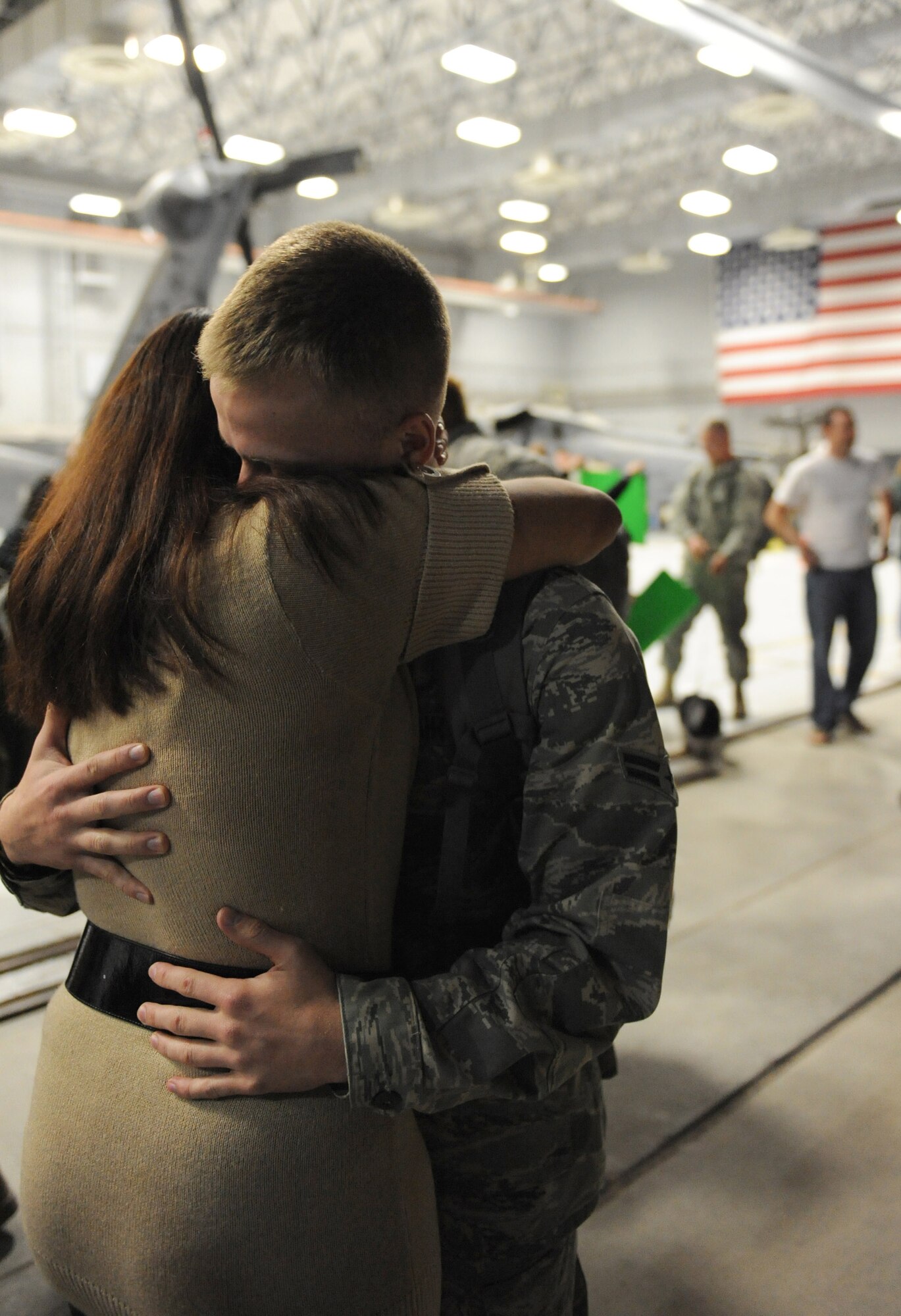 Airman 1st Class Daniel Rodgers embraces his wife, Airman 1st Class Stephanie Rubi, Dec. 6 at Nellis Air Force Base, Nev. Airmen with the 763rd Maintenance Squadron and 66th Rescue Squadron returned home after 3.5 months in Southwest Asia supporting the war on terrorism. He is an HH-60 avionics specialist assigned to the 763rd MXS and she is a still photographic apprentice assigned to the 99th Air Base Wing  (U.S. Air Force photo/Senior Airman Larry E. Reid Jr.)
