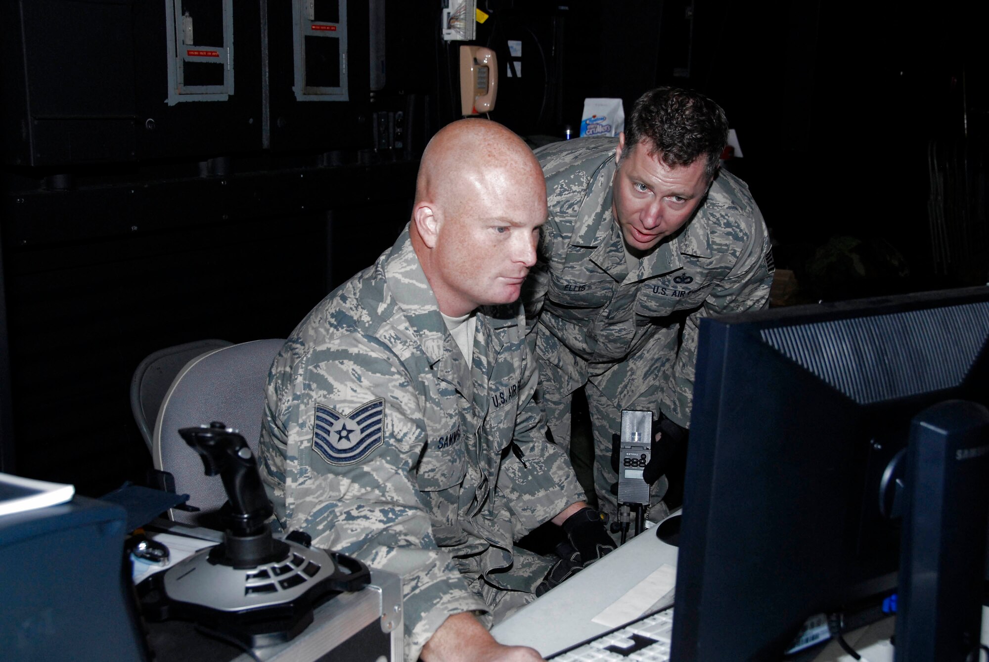 Tech. Sergeants Jody Sammons and Jay Ellis manage a computer-generated scenario that is based on their real-world convoy experiences in Iraq in October at Volk Field, Wis. (U.S. Air Force photo/Master Sgt. Dan Richardson)