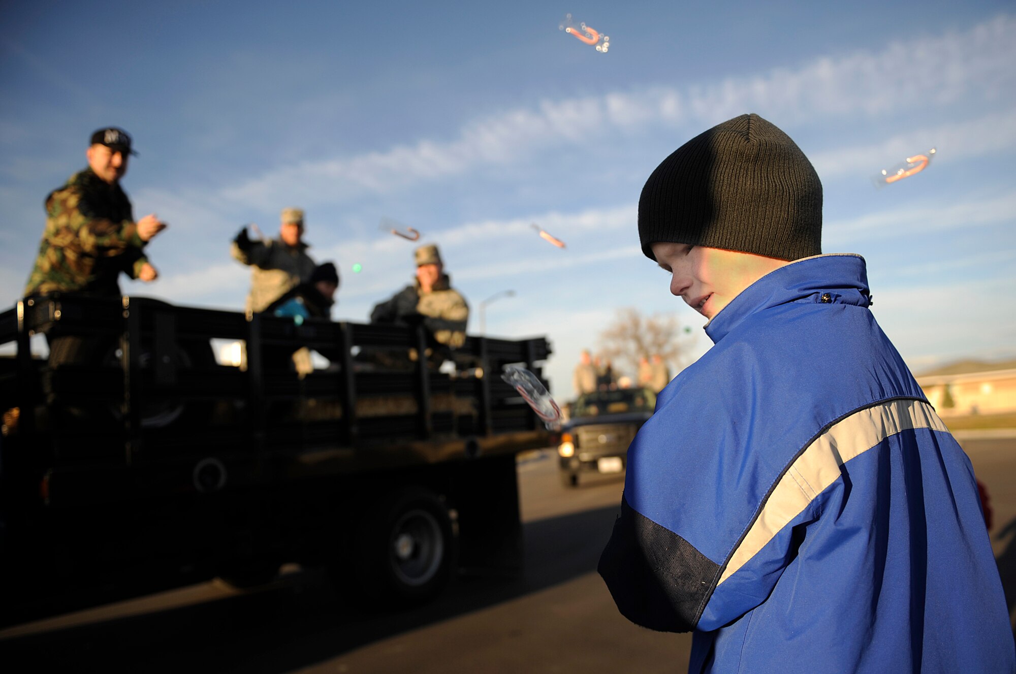 MOUNTAIN HOME AIR FORCE BASE, Idaho – Members of the 366th Maintenance Group toss candy to children during the holiday parade Dec. 3. The First Sergeants Association and base chapel teamed up to bring holiday cheer with a holiday parade followed by a Christmas tree lighting ceremony. After the ceremony, hot chocolate, hot apple cider, cookies and pictures with Santa Claus were available in the chapel. (U.S. Air Force photo/Airman 1st Class Ryan Crane)