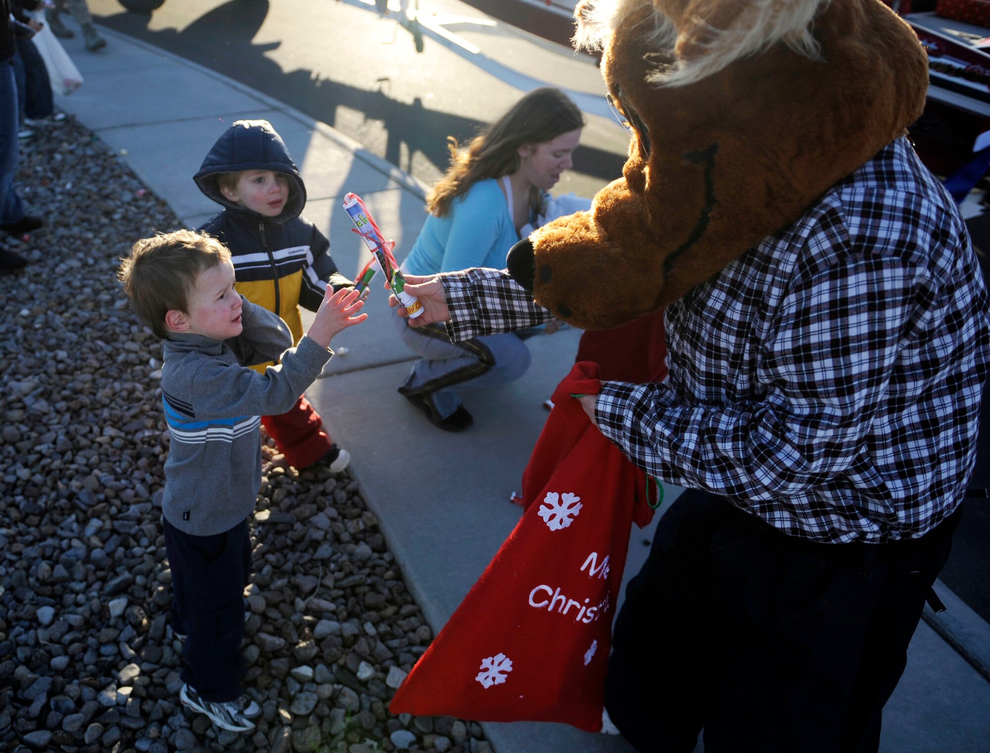 MOUNTAIN HOME AIR FORCE BASE, Idaho – A Youth Programs mascot hands candy out to children during the holiday parade Dec. 3. The First Sergeants Association and base chapel teamed up to bring holiday cheer with a holiday parade followed by a Christmas tree lighting ceremony. After the ceremony, hot chocolate, hot apple cider, cookies and pictures with Santa Claus were available in the chapel. (U.S. Air Force photo/Airman 1st Class Ryan Crane)