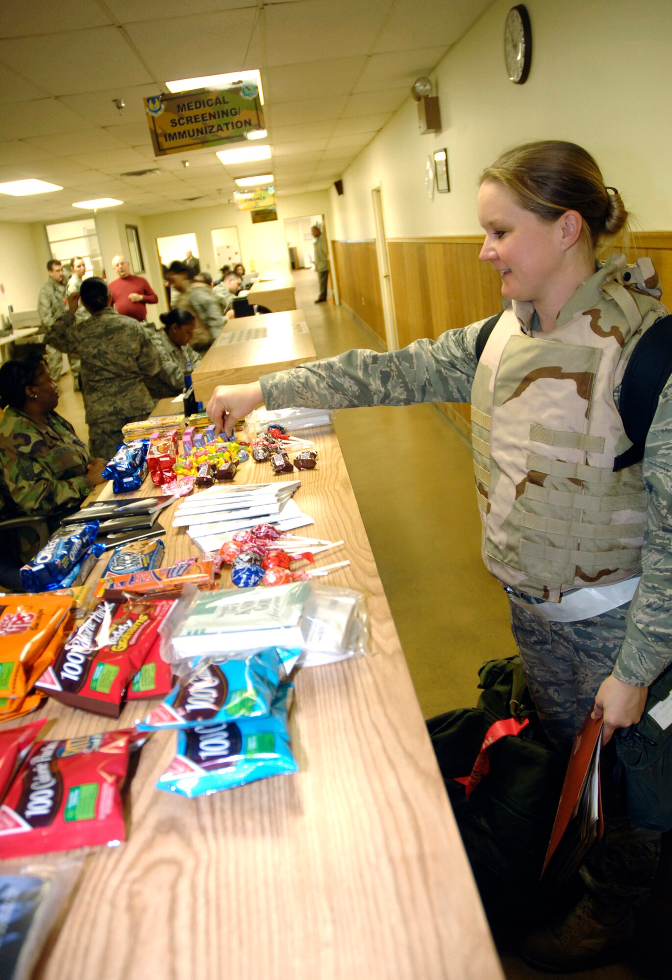Capt. Katie Tanner, program manager for the Modular Aircrew Common Helmet with Aeronautical Systems Center's 77th Aeronautical Systems Wing, enjoys a treat while undergoing personnel deployment processing Dec. 8 at Wright-Patterson Air Force Base.  More than 200 Airmen simulated a crisis response deployment to the U.S. Central Command area of responsibility during the base exercise.  (U.S. Air Force photo/Al Bright)