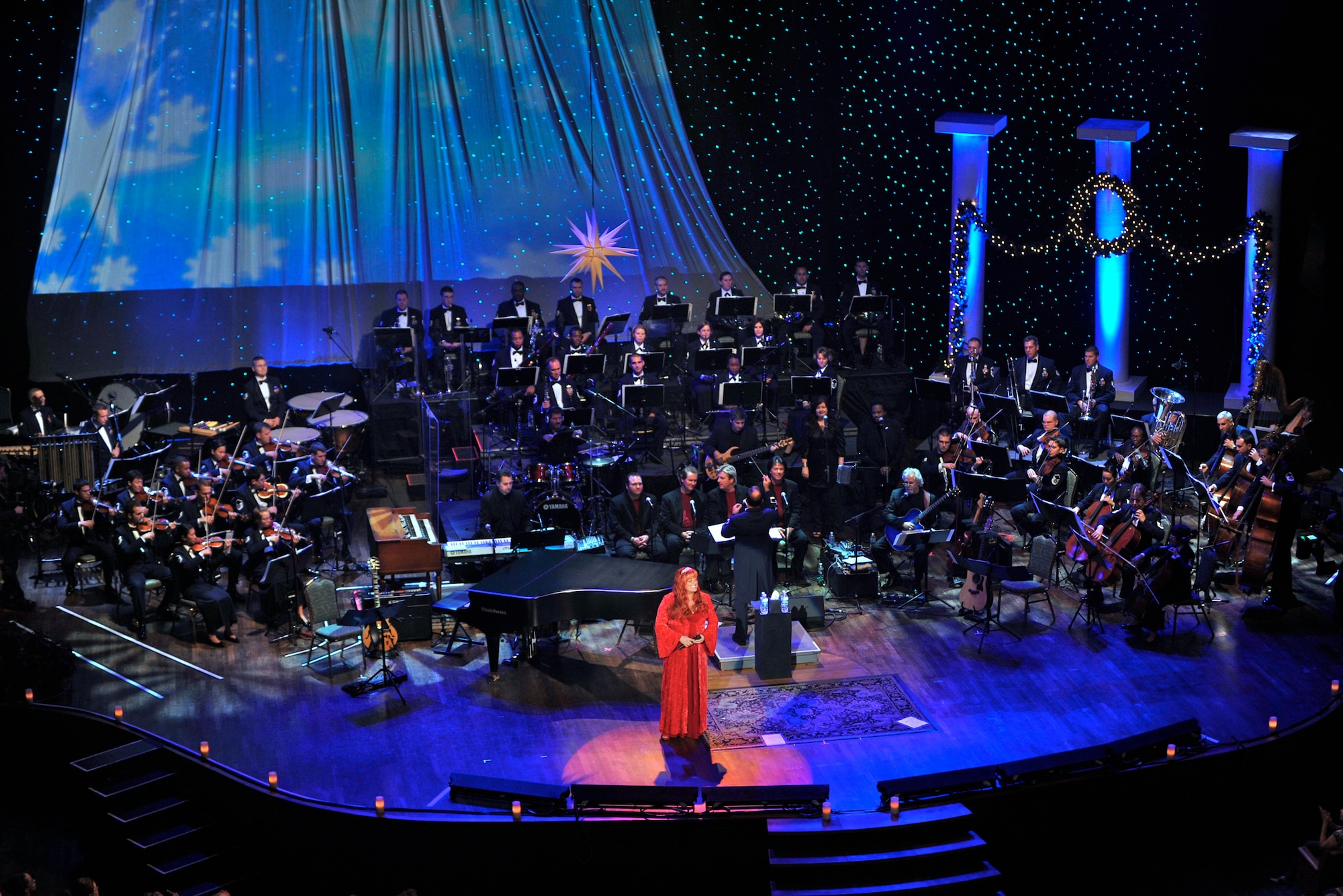 Country music artist Wynonna Judd sings classic holiday music while the Band of the Air Force Reserve and Air Force Strings perform in the background during the 2008 Holiday Notes from Home concert recorded Oct. 6.  Holiday Notes from Home is an annual holiday concert event recorded at the Grand Ole Opry House in Nashville, Tenn., as a tribute to military men and women serving around the world.  The show airs on Great American Country throughout December and also on American Forces Network channels for service members and their families stationed overseas.  (U.S. Air Force photo/Ken Hackman)