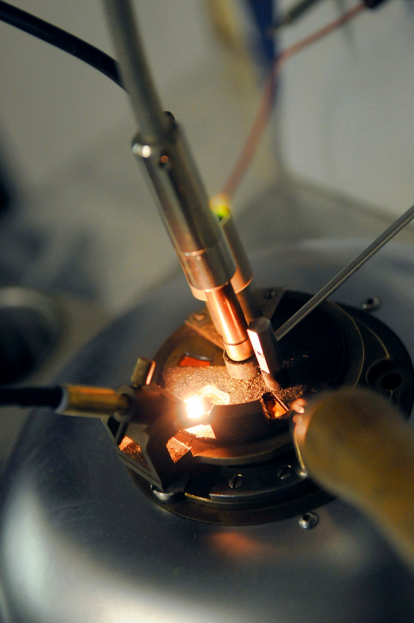 An ignition coil is exposed over JP-8 fumes during a flash point test Dec. 8 at an air base in Southwest Asia. Staff Sgt. Ronald Gasper, a fuels lab technician assigned to the 379th Expeditionary Logistics Readiness Squadron, uses a flash tester to perform a flash point test. The flash point test is used to determine the temperature at which the fuel will ignite. The fuel is slowly warmed and every 2 degrees an ignition coil is briefly exposed over the fuel to identify how hot the fumes must be to ignite. Sergeant Gasper, a native of Omaha, Neb., is deployed from Scott Air Force Base, Ill. (U.S. Air Force photo/Tech. Sgt. Michael Boquette) 
