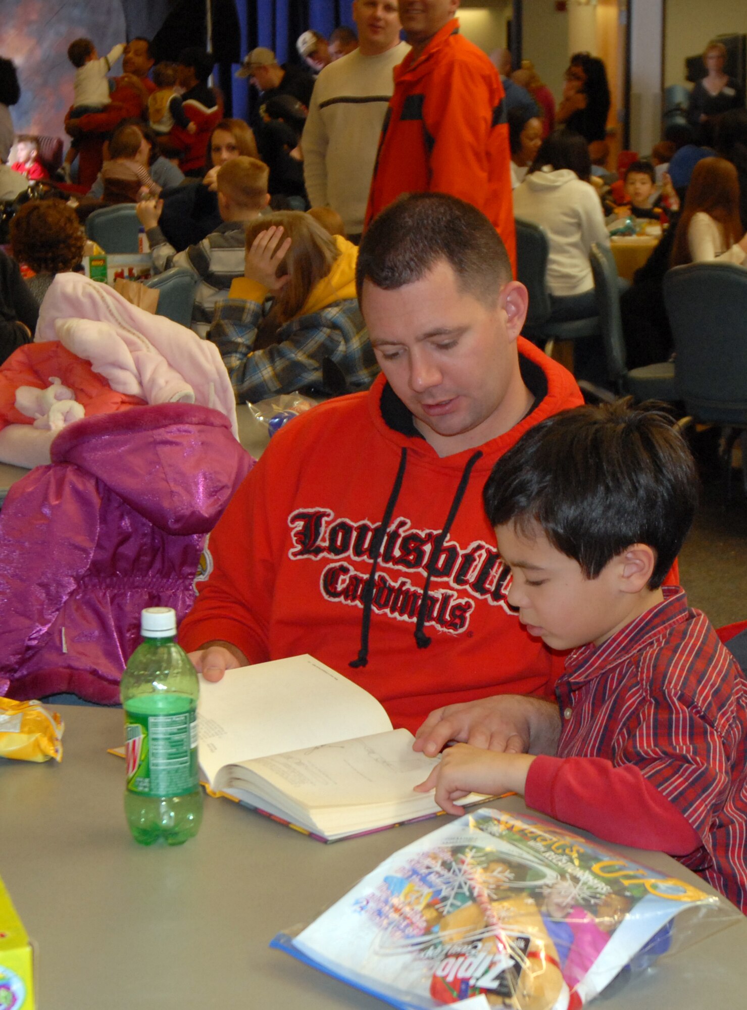 Staff Sgt. James McDonald, 436th Aircraft Maintenance Squadron, stops to read part of a book that his son, Jimmy, won during a raffle at the 2008 Wing Children’s Christmas Party at The Landings Club, Dec. 7. The Dover First Sergeant’s Council teamed up with many off base sponsors to give away many gifts to base children. (U.S. Air Force photo by Tech. Sgt. Kevin Wallace)