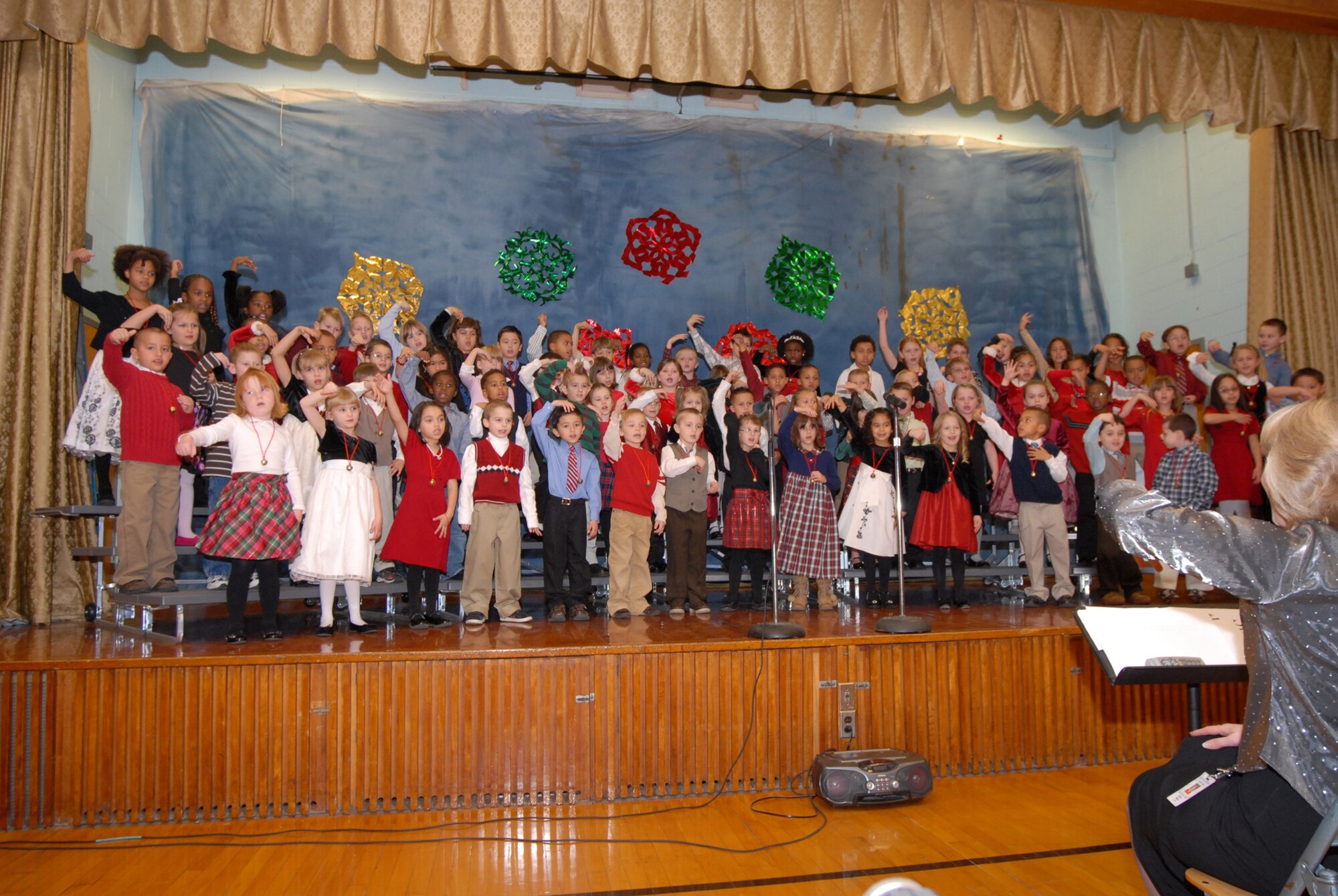 Four first grade classes at Major George S. Welch Elementary School, on Dover Air Force Base, flex their vocal chords in an attempt to bring some Holiday cheer during a concert at their school gymnasium Dec. 5. Diane Walls, music teacher, led the children in the singing of Christmas, Hanukkah and Kwanzaa songs. (U.S. Air Force photo by Tech. Sgt. Kevin Wallace)