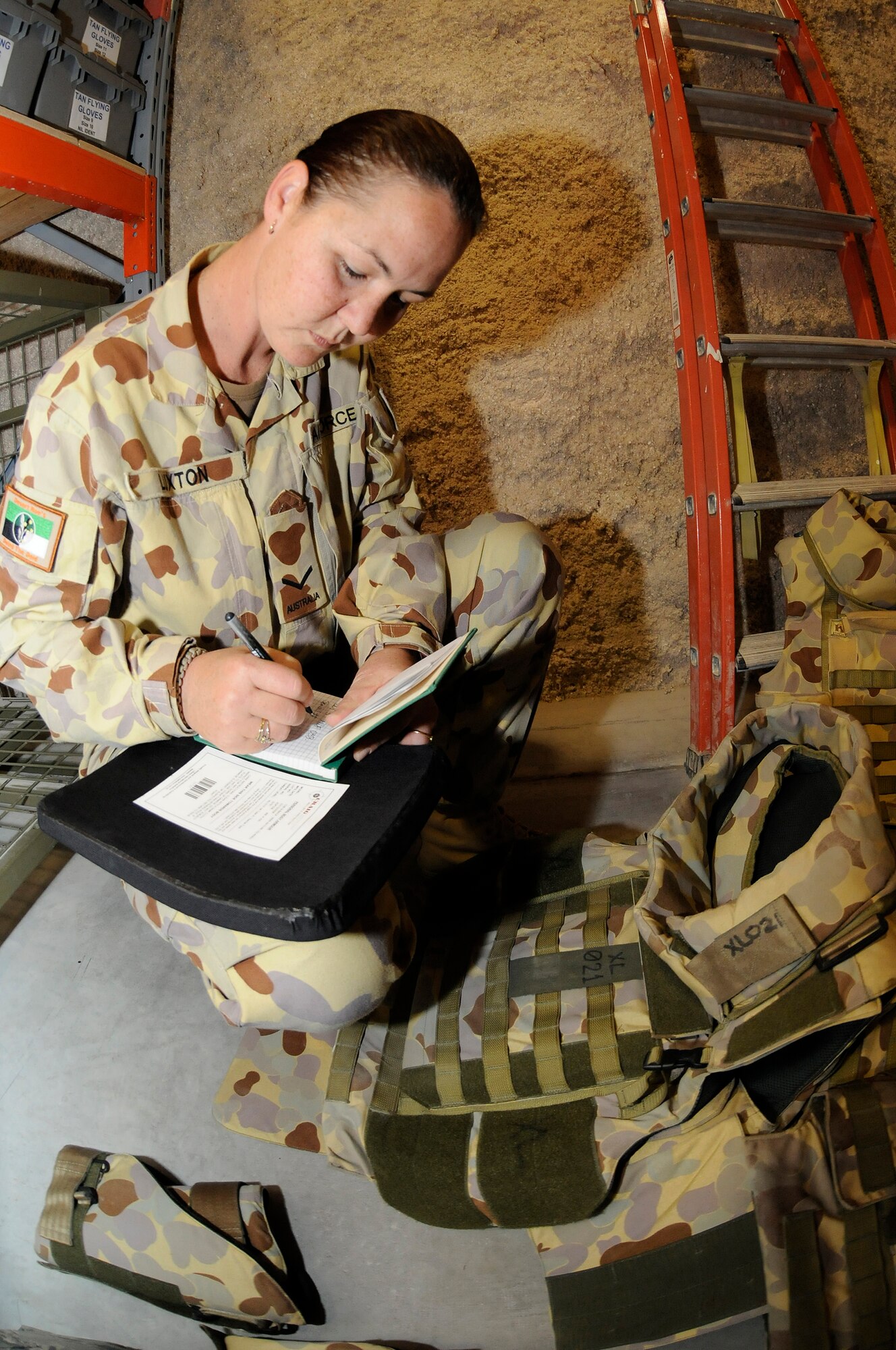 Leading Aircraft Woman Kylie Luxton, warehouse supplier assigned to the 633.4 Task Group, Combat Support Element, performs an inspection of body armor ballistic plates before they are issued to Australian coalition members Dec. 9, at an undisclosed air base in Southwest Asia.  Leading Aircraft Woman Luxton, native of Mount Isa, Queensland, is deployed from Darwin Royal Australian Air Base, Australia, in support of Operations Iraqi and Enduring Freedom. (U.S. Air Force photo by Staff Sgt. Darnell T. Cannady/Released)