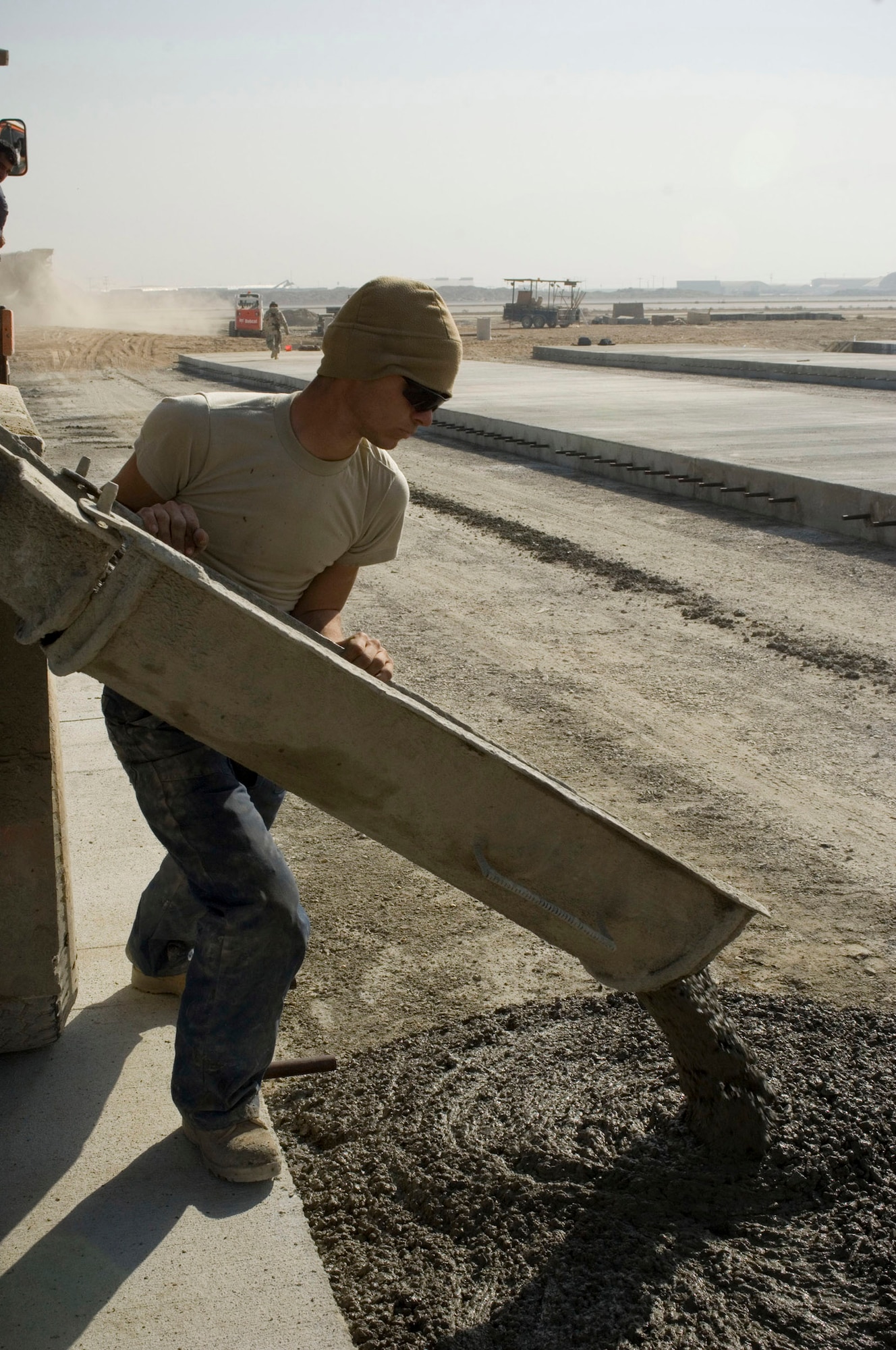Airman 1st Class Christopher Gaudette, a 455th Expeditionary Civil Engineer Squadron "dirt boy," pours concrete from a truck on the flightline at Bagram Air Field, Afghanistan, Nov. 25. Since August the 455th ECES has poured more than 2,075 cubic meters of concrete as part of construction projects designed to expand the airfield. Airman Gaudette is deployed from Pope Air Force, N.C. (U.S. Air Force photo by Staff Sgt. Rachel Martinez) (Released)
