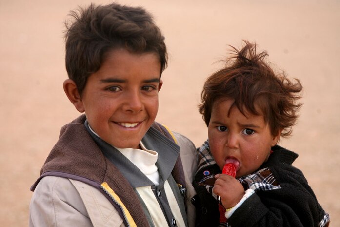 A young Iraqi girl eats a piece of candy that was given to her by Marines with Company A, 2nd Tank Battalion, Regimental Combat Team 5 during a humanitarian mission in al-Anbar province, Iraq, Dec. 10. The Marines and sailors with Company A conducted operations in the area as part of Task Force Mech, RCT-5.  Conducting security patrols and interacting with the local Iraqi civilians have afforded the service members an opportunity to distribute food, water and medical supplies.  The Marines and sailors with Task Force Mech have also provided medical care to the local Iraqis
