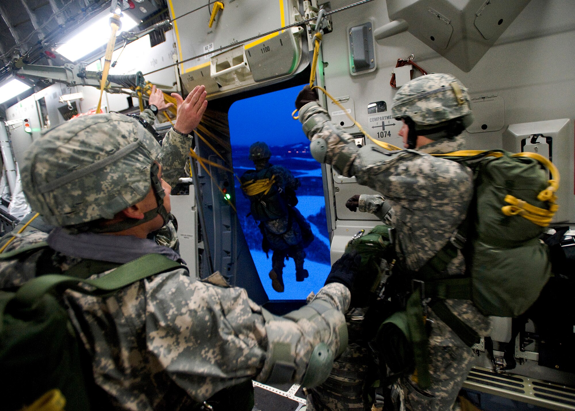 ELMENDORF AIR FORCE BASE, Alaska -- Soldiers from 1-501 Infantry jump out the troop door from a C-17 Globemaster III Dec. 10. The 4th Brigade Combat Team, 25th Infantry Division partnered with the 517th Airlift Squadron, Hickam and McCord Air Force Base is using this week practice jumps prior to the deployment. Roughly 1,300 4-25 Soldiers will be jumping out of C-17 Globemaster IIIs during the week. (U.S. Air Force photo/Senior Airman Jonathan Steffen)