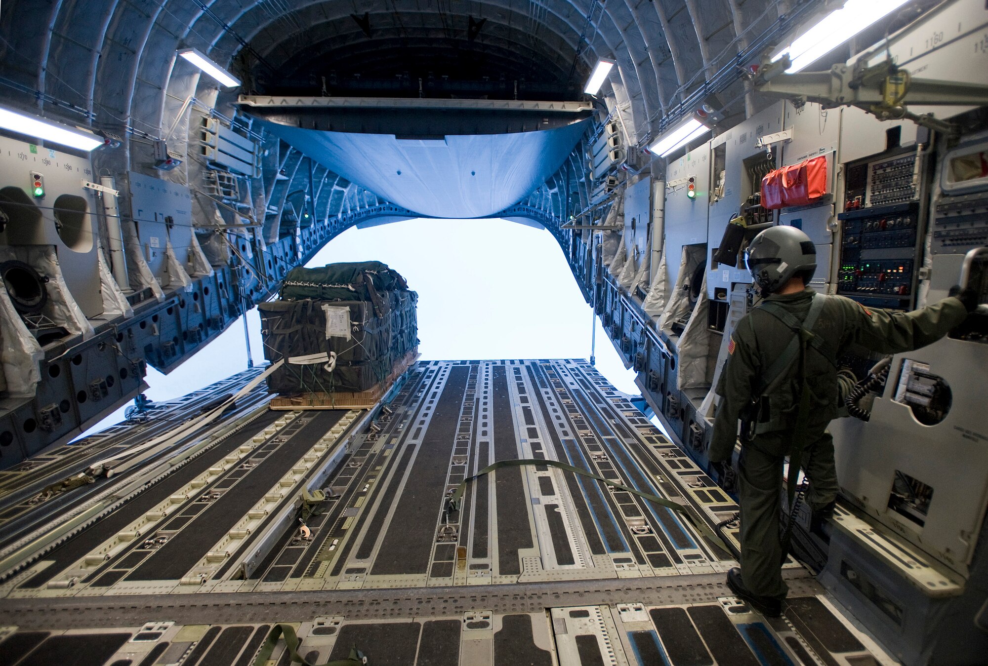 ELMENDORF AIR FORCE BASE, Alaska -- Staff Sgt. Jason Jones, 535th Airlift Squadron, watches as Container Delivery System bundle flies off the ramp Dec. 10. The 4th Brigade Combat Team, 25th Infantry Division partnered with the 517th Airlift Squadron, Hickam and McCord Air Force Base is using this week practice jumps prior to the deployment. Roughly 1,300 4-25 Soldiers will be jumping out of C-17 Globemaster IIIs during the week. (U.S. Air Force photo/Senior Airman Jonathan Steffen)