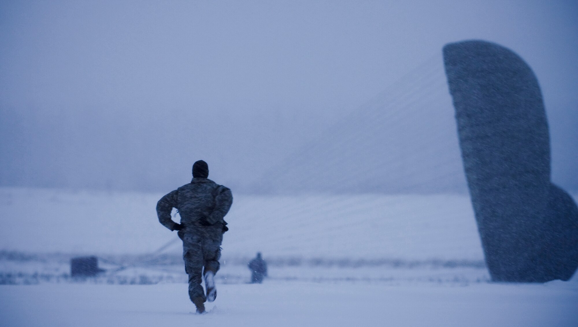 FORT RICHARDSON, Alaska -- Army Specialist Brad Urban, 1-501 Infantry, runs out to help collapse a parachute attached to Container Delivery System Dec. 10. The 4th Brigade Combat Team, 25th Infantry Division partnered with the 517th Airlift Squadron is using this week practice jumps prior to the deployment. Roughly 1,300 4-25 Soldiers will be jumping out of C-17 Globemaster IIIs during the week. (U.S. Air Force photo/Airman 1st Class Cynthia Spalding)