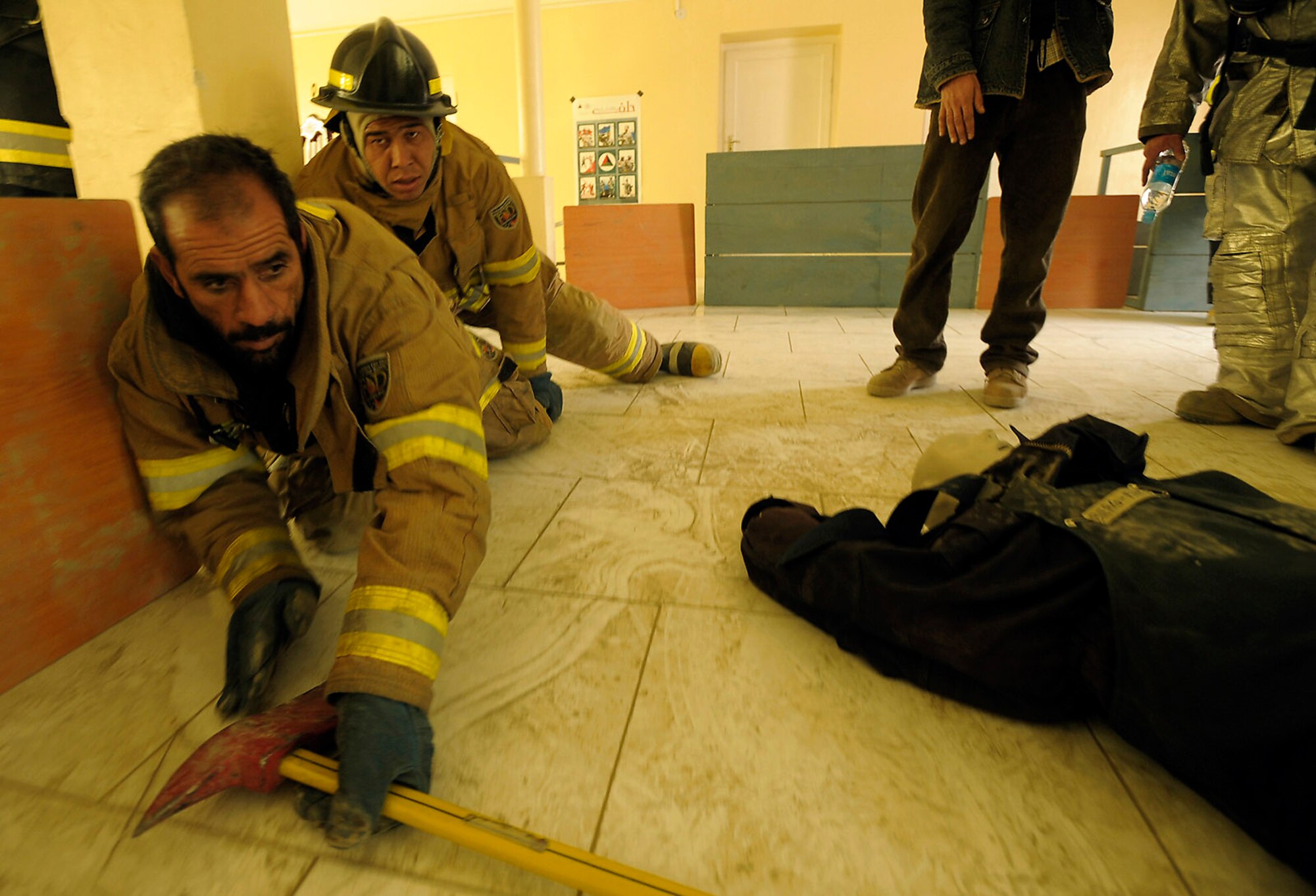 Two Afghan National Army Air Corps firefighters simulate locating a victim in a smoke filled room during a demonstration at the Afghan Joint Fire Academy in Kabul, Afghanistan, recently. (U.S. Air Force photo/Master Sgt. Keith Brown)