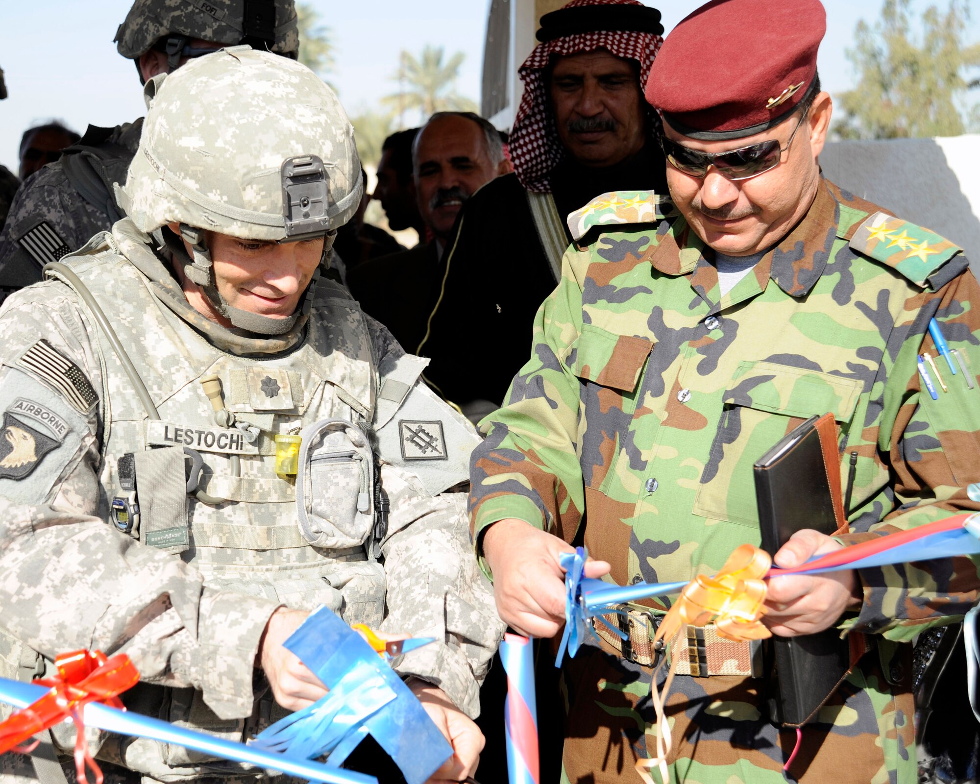 U.S. Army Lt. Col. Christopher Lestochi (left) and a senior Iraq army officer cut the ceremonial ribbon for the opening of the community center Dec. 5 in Hawr Rajab, Iraq. Colonel Lestochi is the commander 54th Engineer Battalion. (U.S. Air Force photo/Staff Sgt. Paul Villanueva II) 
