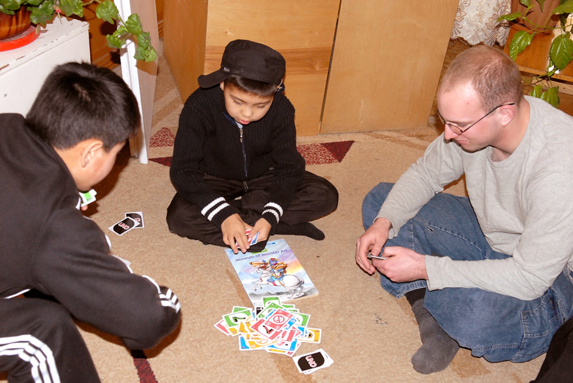 Airman 1st Class Nick Gray-Bakker plays UNO with children who are awaiting heart surgery Dec. 3 in Bishkek, Kyrgyzstan. Over the past five years, $71,680 of contributions from Manas Air Base, Kyrgyzstan, Airmen have funded heart operations on 128 children. Airman Gray-Bakker is assigned to the 376th Expeditionary Logistics Readiness Squadron. (U.S. Air Force photo/Senior Airman Ruth Holcomb) 
