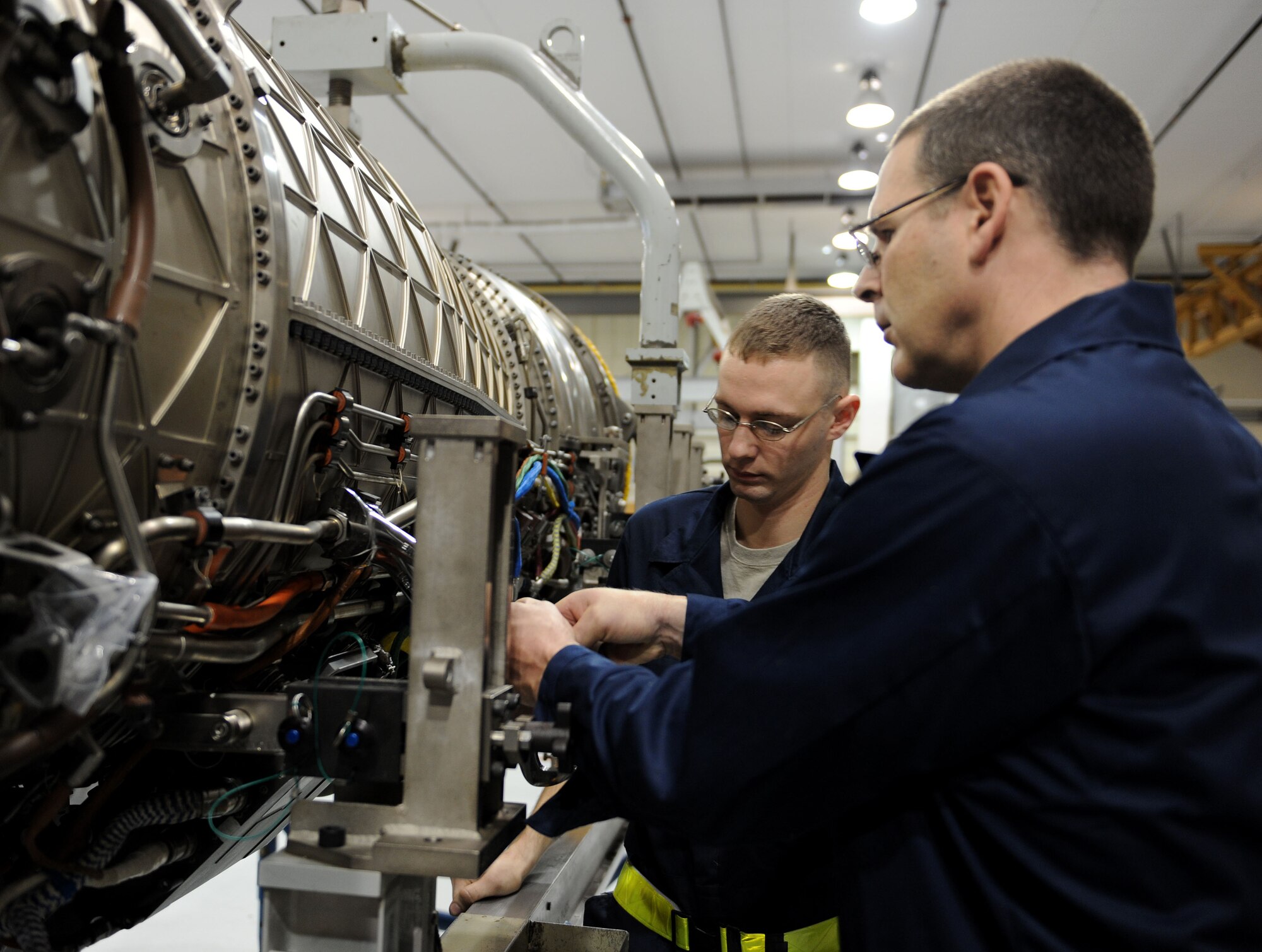 LANGLEY AIR FORCE BASE, Va. --  Chief Master Sgt. Kevin Slater, 1st Fighter Wing command chief, works on the engine of an F-22 with the help on Senior Airman Justin Laraby at the 1st Component Maintenance Squadron Dec. 10. Chief Slater toured the squadron and received a lesson on the engines while getting to know some of the Airmen.  (U.S. Air Force photo/Airman Rebecca Montez)