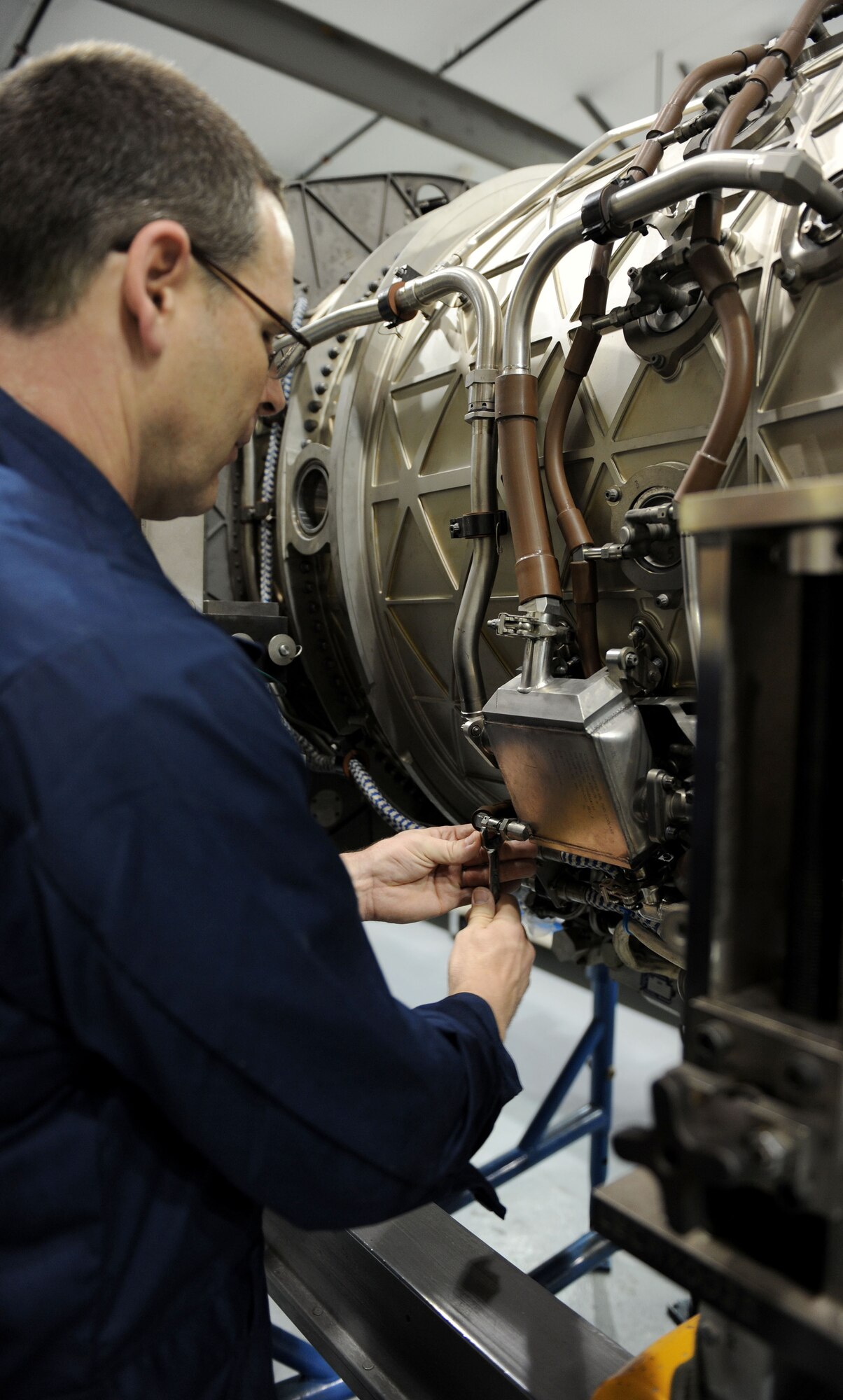 LANGLEY AIR FORCE BASE, Va. -- Chief Master Sgt. Kevin Slater, 1st Fighter Wing command chief, works on the engine of an F-22 at the 1st Component Maintenance Squadron Dec. 10. Chief Slater toured the squadron and received a lesson on the engines while getting to know some of the Airmen.  (U.S. Air Force photo/Airman Rebecca Montez)
