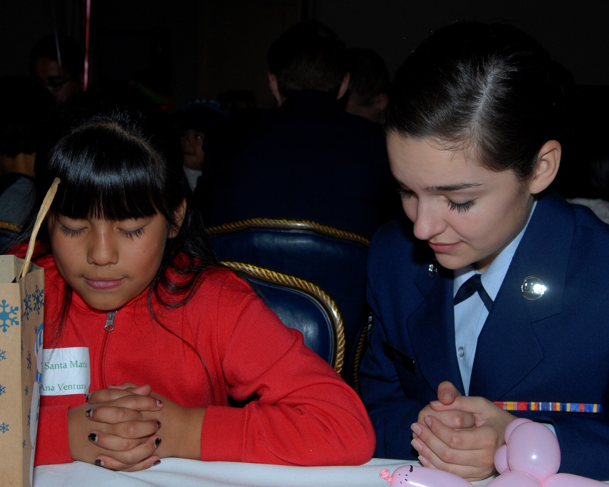 VANDENBERG AIR FORCE BASE Calif. -- Airman 1st Class Dallas Cole prays with 
Ana Ventura from Santa Maria at Operation Kids Christmas held at the Pacific Coast Club. (U.S. Air Force photo/Airman 1st Class Antoinette Lyons)