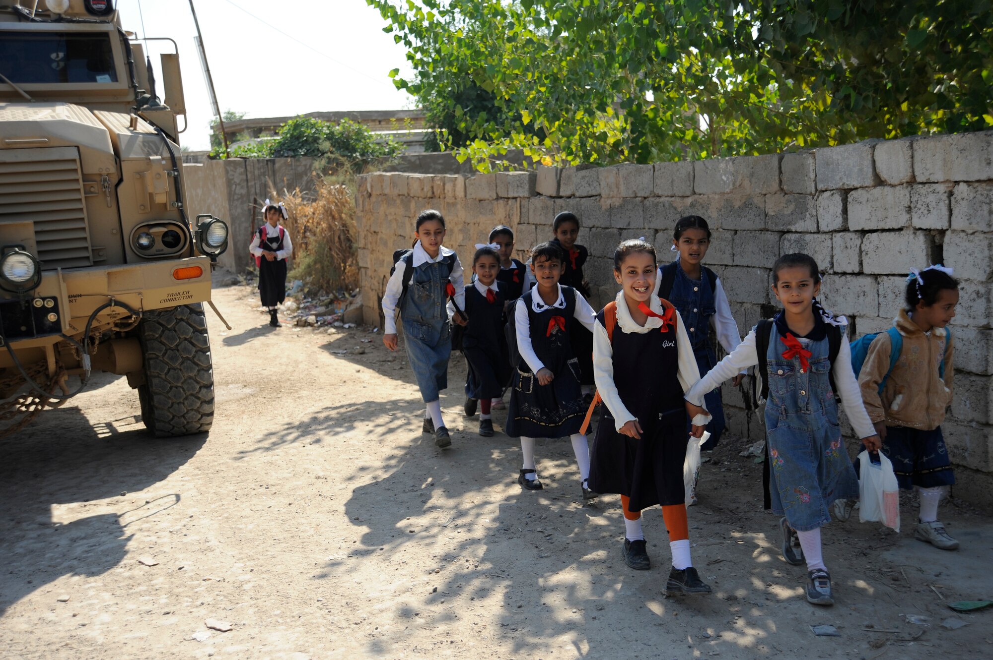 HAWR RAJAB, Iraq -- Iraqi school girls walk past a Mine Resistant Ambush Protective vehicle on their way to school in Hawr Rajab, Iraq. (U.S. Air Force photo/Staff Sgt. Paul Villanueva II)