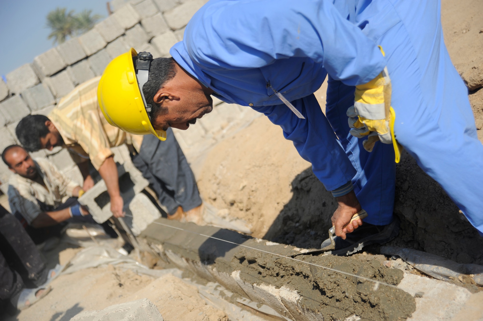 HAWR RAJAB, Iraq -- A graduate of the Village of Hope program lays cement for the construction of a security wall around the community center in Hawr Rajab, Iraq. (U.S. Air Force photo/Staff Sgt. Paul Villanueva II)