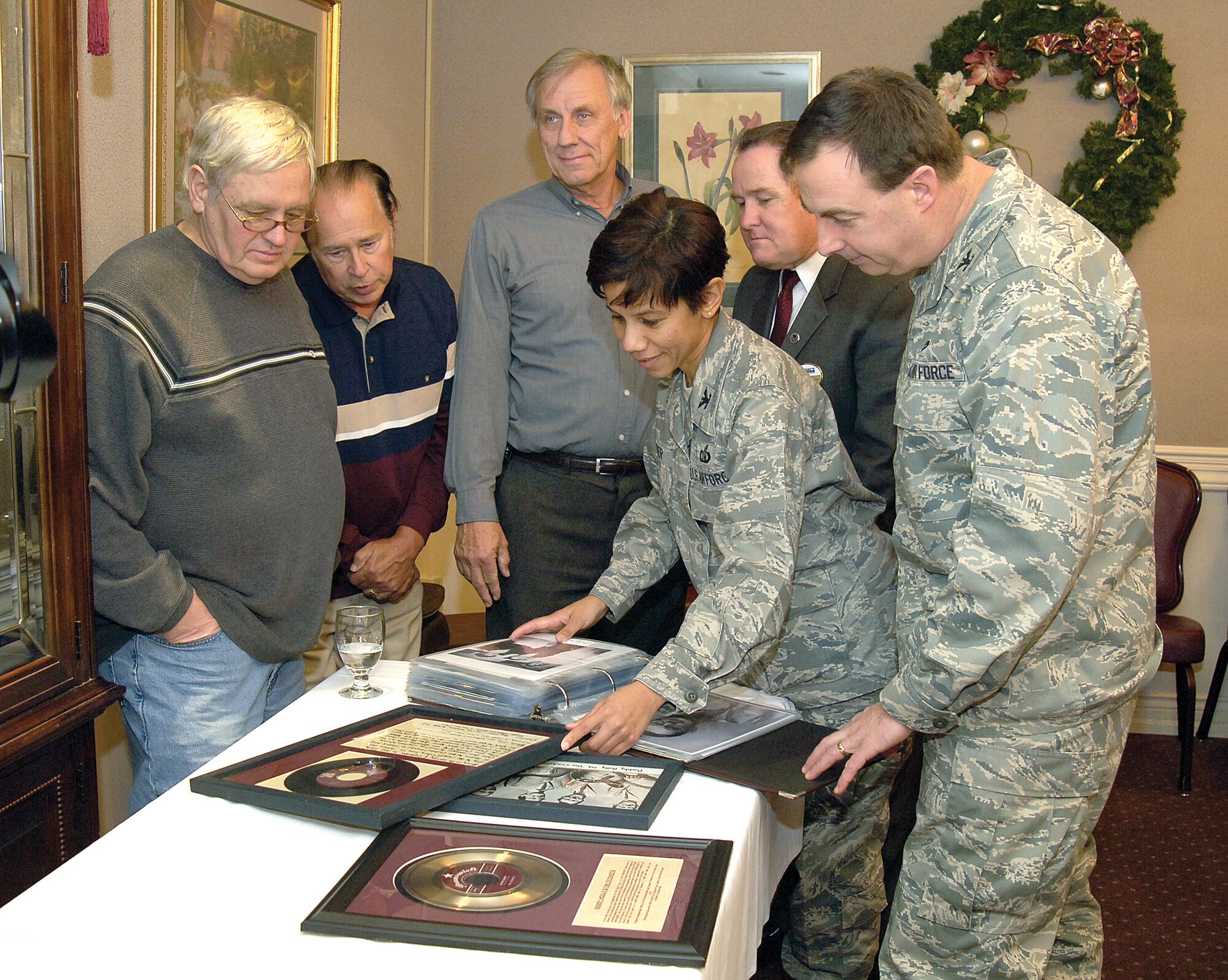 From left: Danny Todd; Kevin Terry; Graham Pugh; Col. Mona Lisa Tucker, 72nd Air Base Wing vice commander; Dan Bell, 72nd Force Support Squadron director and Col. James Eilers, 72nd Mission Support Group Commander, look over the plaques presented to the Tinker club which will now more officially link a long-rumored Buddy Holly recording session to Tinker’s old Officer’s Club.(Air Force photo by/Margo Wright) 
