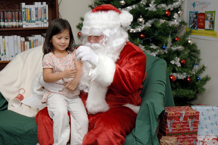 Julianne Dalope receives a candy cane from Santa Claus while she sits on his lap during the holiday classics party Dec. 9 at the base library. More than 20 children attended the party where they listened to stories, sang carols, made crafts and interacted with Santa. Julianne is the daughter of JoAnne and Staff Sgt. Marc Dalope who is assigned to the 437th Civil Engineer Squadron. (U.S. Air Force photo/Staff Sgt. Marie Cassetty)