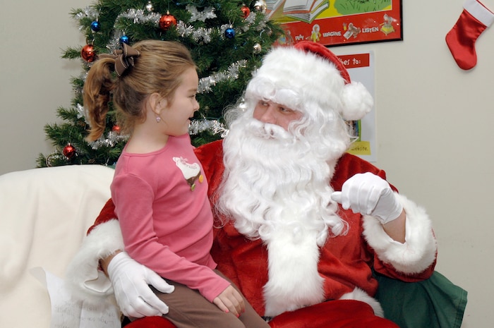 Audrey Elms tells Santa Claus what she wants for Christmas while attending the holiday classics party Dec. 9 at the base library. More than 20 children attended the party where they listened to stories, sang carols, made crafts and interacted with Santa. Audrey is the daughter of Jamie and Tech. Sgt. Jamey Elms who is assigned to the 437th Maintenance Squadron. (U.S. Air Force photo/Staff Sgt. Marie Cassetty)
