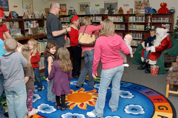 Children from Charleston AFB and Naval Weapons Station, Charleston, stand in line to have their photo taken with Santa Claus during the holiday classics party Dec. 9 at the base library. More than 20 children attended the party where they listened to stories, sang carols, made crafts and interacted with Santa. (U.S. Air Force photo/Staff Sgt. Marie Cassetty)
