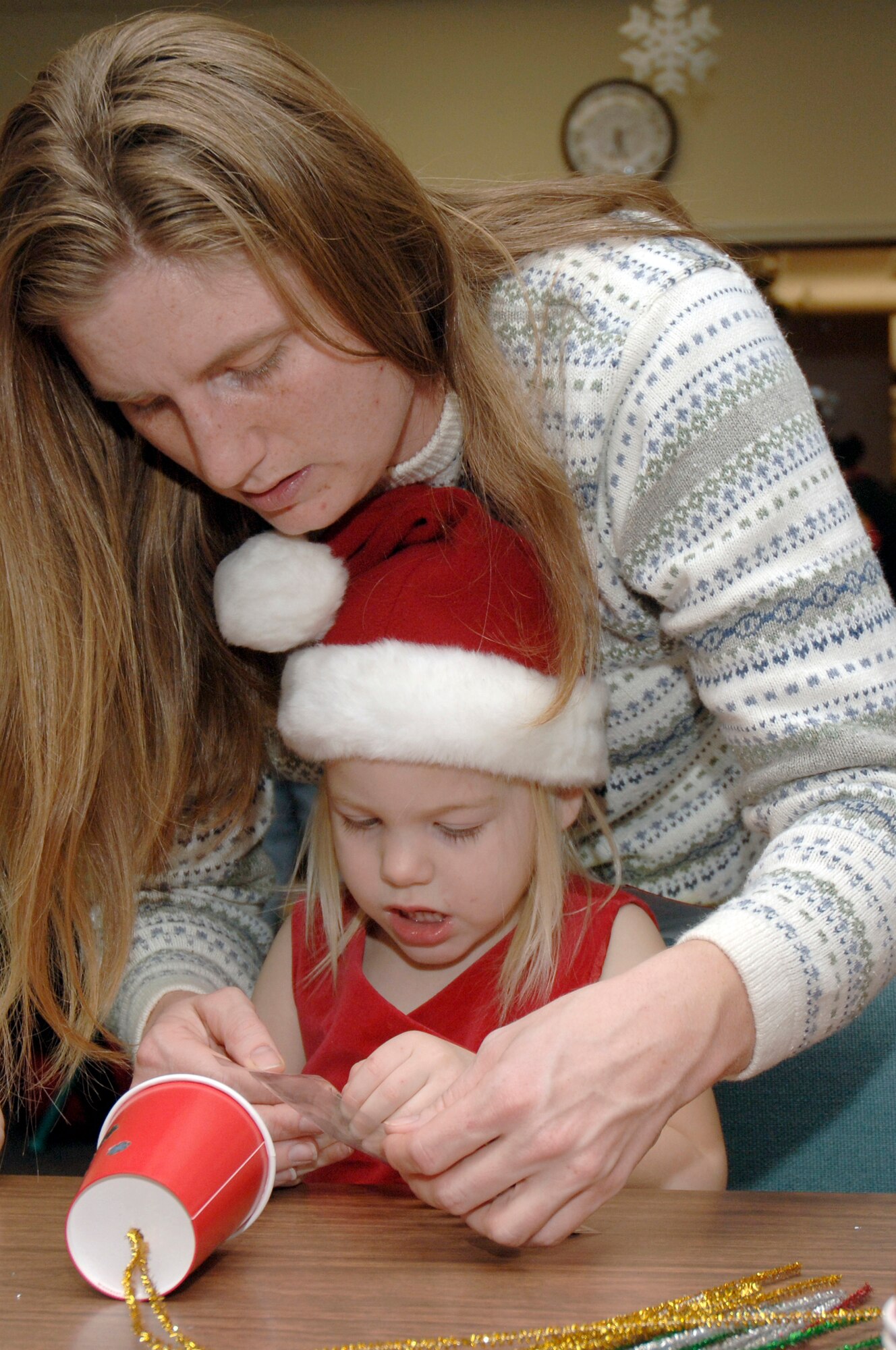 Michele Starkey helps her daughter, Elizabeth, make a tree ornament during the holiday classics party Dec. 9 at the base library. More than 20 children attended the party where they listened to stories, sang carols, made crafts and interacted with Santa. Elizabeth is also the daughter of Tech. Sgt. Sean Starkey who is assigned to the 437th Aircraft Maintenance Squadron. (U.S. Air Force photo/Staff Sgt. Marie Cassetty)