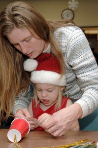 Michele Starkey helps her daughter, Elizabeth, make a tree ornament during the holiday classics party Dec. 9 at the base library. More than 20 children attended the party where they listened to stories, sang carols, made crafts and interacted with Santa. Elizabeth is also the daughter of Tech. Sgt. Sean Starkey who is assigned to the 437th Aircraft Maintenance Squadron. (U.S. Air Force photo/Staff Sgt. Marie Cassetty)