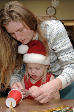 Michele Starkey helps her daughter, Elizabeth, make a tree ornament during the holiday classics party Dec. 9 at the base library. More than 20 children attended the party where they listened to stories, sang carols, made crafts and interacted with Santa. Elizabeth is also the daughter of Tech. Sgt. Sean Starkey who is assigned to the 437th Aircraft Maintenance Squadron. (U.S. Air Force photo/Staff Sgt. Marie Cassetty)