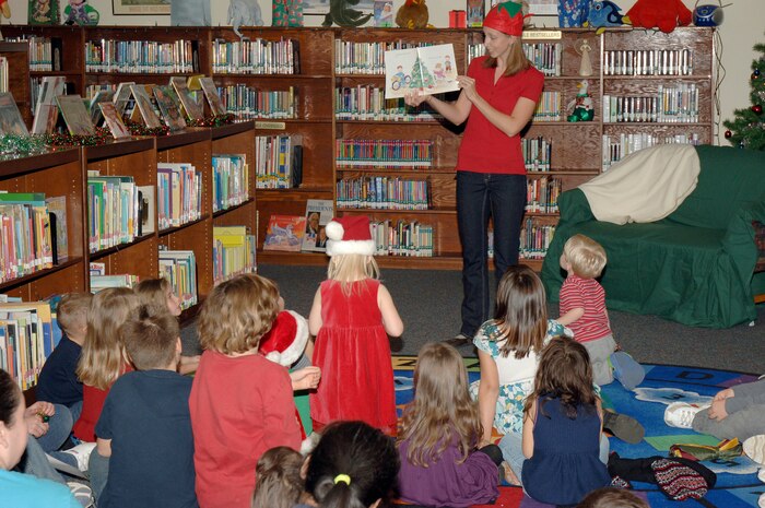 Lindsey Myers reads a classic holiday story to children from Charleston AFB and Naval Weapons Station, Charleston, during the holiday classics party Dec. 9 at the base library. More than 20 children attended the party where they listened to stories, sang  carols, made crafts and interacted with Santa. Lindsey is the program events coordinator for the base library. (U.S. Air Force photo/Staff Sgt. Marie Cassetty)