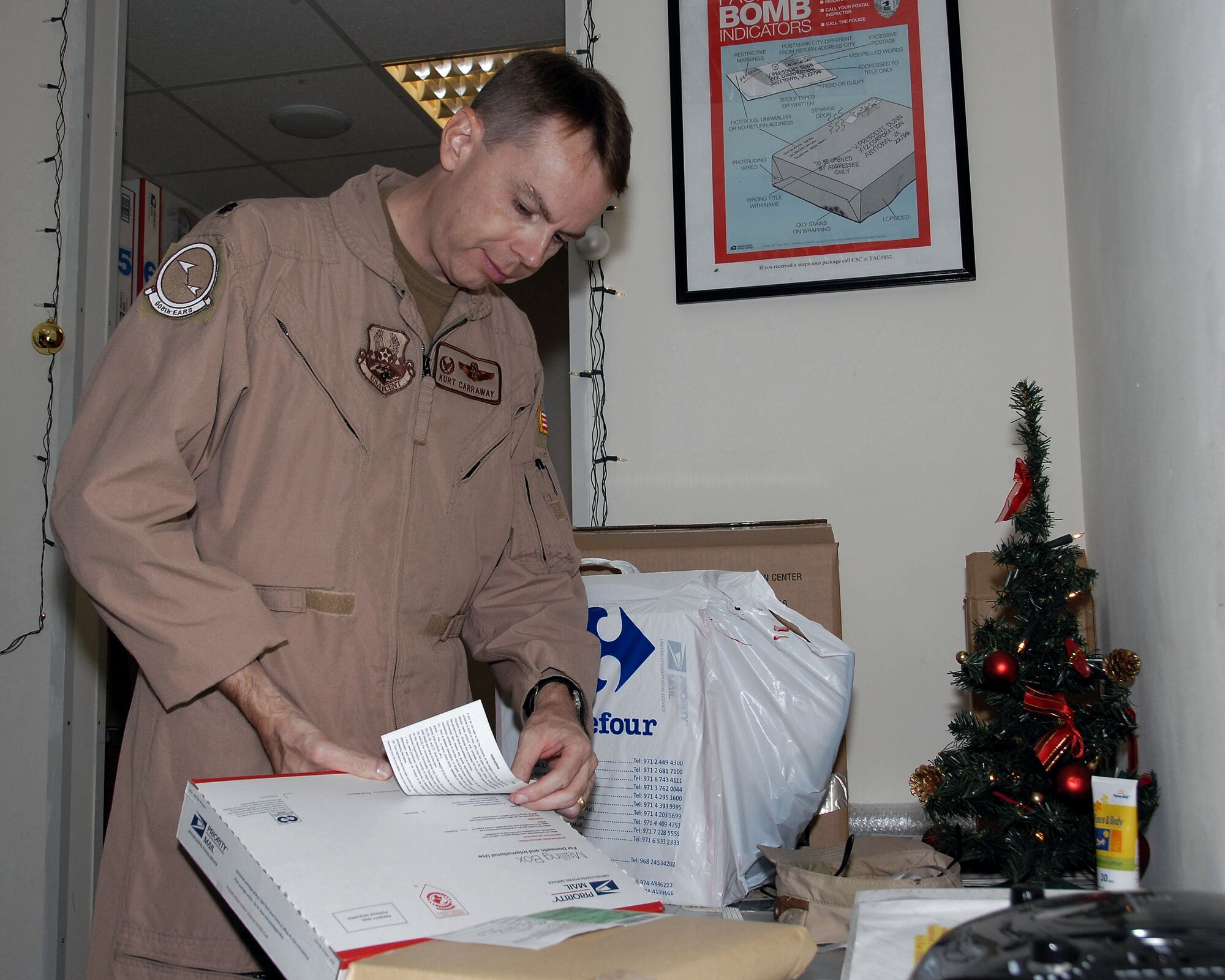 Lt. Col. Kurt Carraway prepares a holiday package in the customer-service area of the 380th Air Expeditionary Wing Post Office Dec. 9 at an air base in Southwest Asia. Colonel Carraway is mailing a package to his family in St. Louis. The package is one of many processed by the post office staff totaling nearly a million kilos of mail since the beginning of the year. Colonel Carraway is the 380th Expeditionary Operations Group deputy commander. (U.S. Air Force photo/Tech. Sgt. Denise Johnson) 
