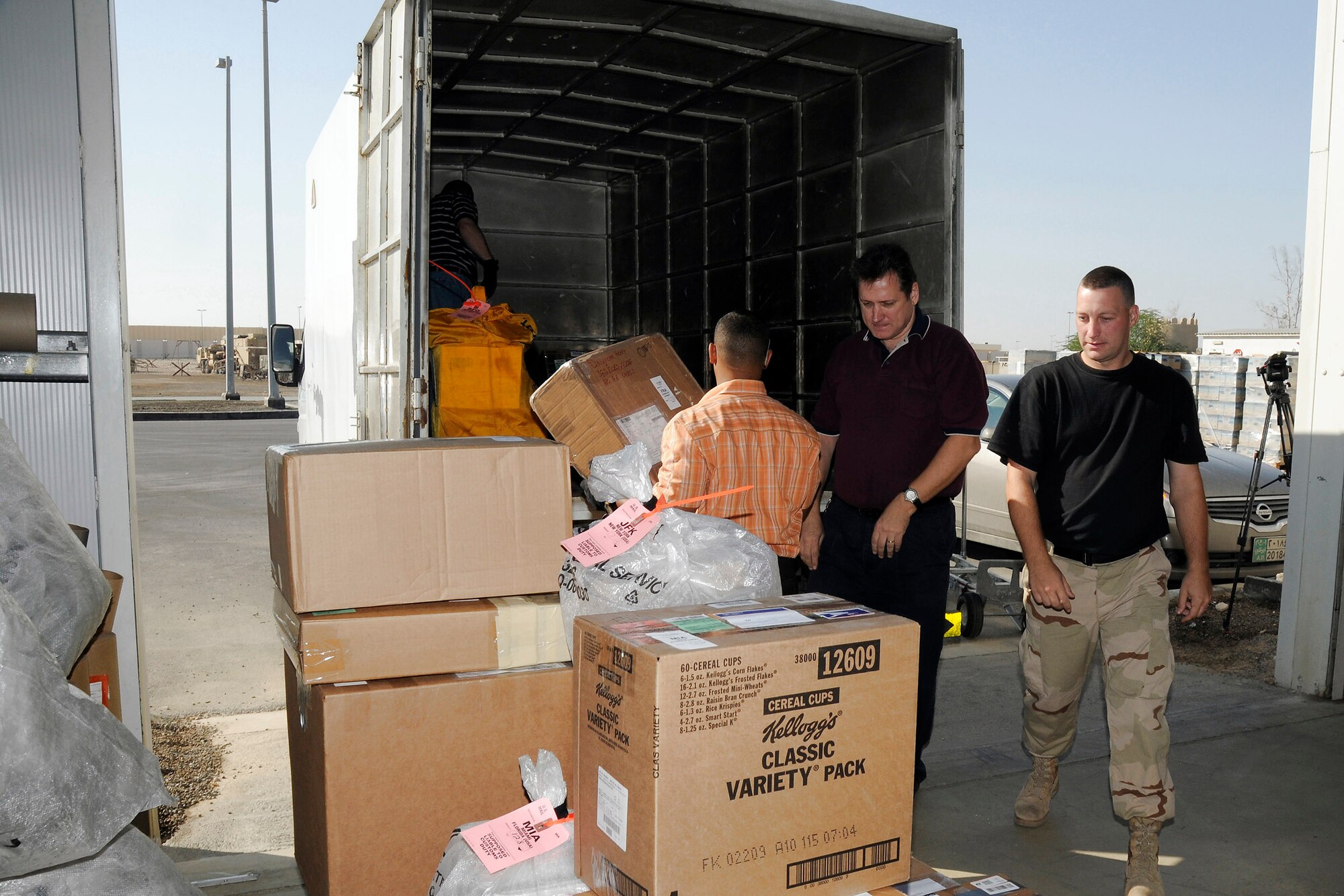 Mike Ruzza, Oneris Barett, Scott Kirsch and Senior Airman Christopher Teixeira load a mail truck with outgoing mail Dec. 8 at an air base in Southwest Asia. Airman Teixeira is with the 380th Expeditionary Civil Engineer Fire and Emergency Services. The civilians work for Alutiiq International Solutions LCC, which is contracted to provide personnel and services for the 380th Air Expeditionary Wing's Post Office. Mr. Ruzza is a native of Tampa Bay, Fla. Mr. Barett is from the Bronx, N.Y. Mr. Kirsch hails from Toledo, Ohio, and Airman Teixeira is deployed from Ellsworth Air Force Base, S.D., and his hometown is Battle Creek, Mich. (U.S. Air Force photo/Tech. Sgt. Christopher A. Campbell)
