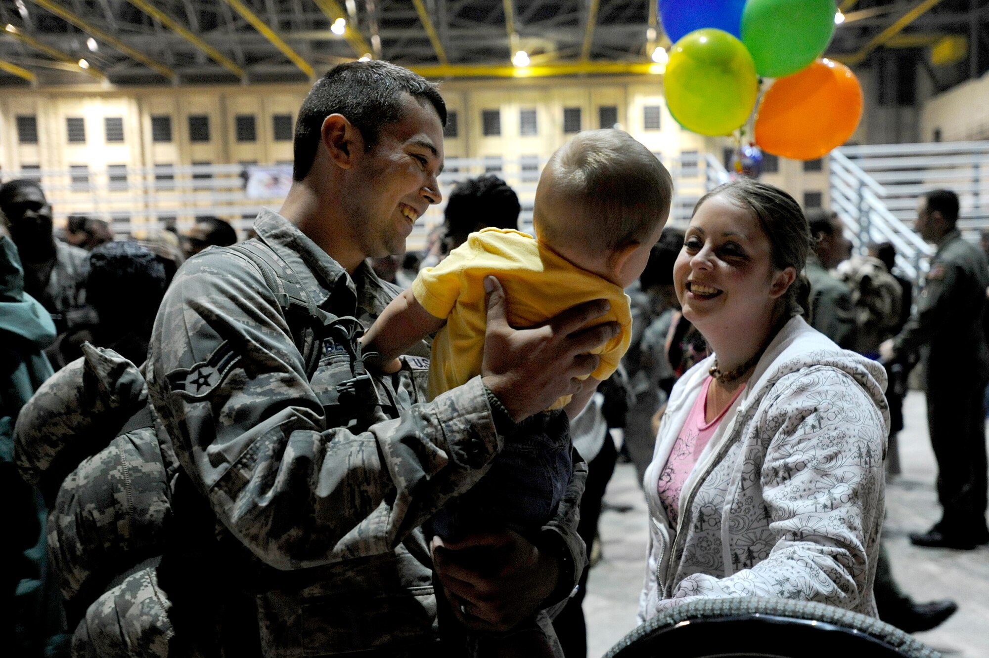 EGLIN AIR FORCE BASE, Fla. -- Airman 1st Class Frank Bender, 1st Special Operations Equipment Maintenance Squadron, embraces his daughter and wife during Operation Homecoming, Dec. 9. As the first Airman stepped down the stairs from the plane onto the tarmac, the aircraft hangar where friends and families anxiously waited came alive with cheers and tears. In a matter of minutes, more than 200 Airmen were reunited with their loved ones. (U.S. Air Force photo /Senior Airman Julianne Showalter)