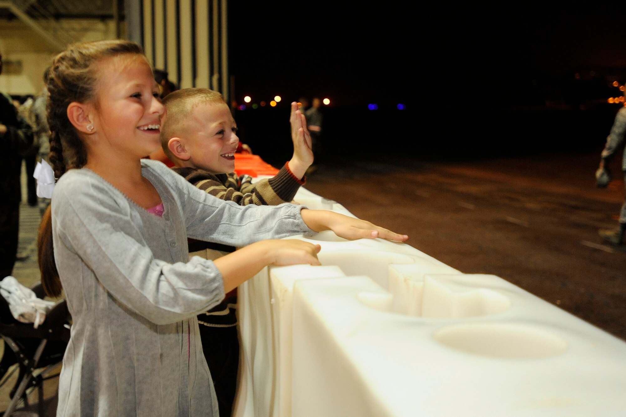 EGLIN AIR FORCE BASE, Fla. -- Anna-Grace and Hayden Brammer spot their dad, Tech. Sgt. Jerry Brammer, and wave excitedly during Operation Homecoming, Dec. 9. Operation Homecoming gives friends and family the opportunity to greet loved ones who are returning from deployment as they depart the plane. (U.S. Air Force photo /Senior Airman Julianne Showalter)
