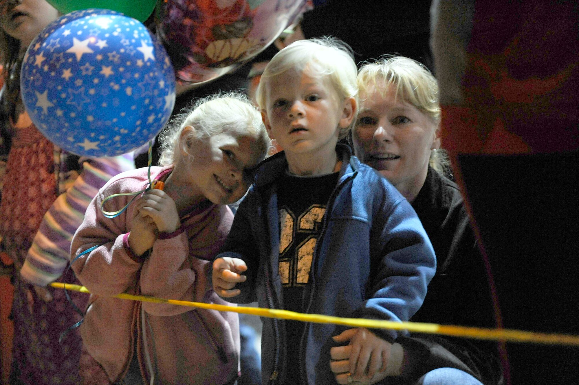 EGLIN AIR FORCE BASE, Fla. -- Michelle Peck and her two children, Maddeline and Jesse, search through the many faces for their dad, Lt. Col Jon Peck, 18th Flight Test Squadron commander, as Airmen step off the aircraft and walk into the hangar during Operation Homecoming, Dec. 9. (U.S. Air Force photo /Senior Airman Julianne Showalter)