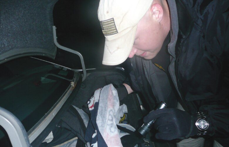 Special Agent  Dustin McLeod, Air Force Office of Special Investigations, Det. 301, searches a vehicle during a gate interdiction operationhis detachment conducted recently. The operation yielded some useful local intelligence and showed the Scott Air Force Base community that AFOSI and security forces were focusing on base security. (U.S. Air Force photo/Special Agent John Nottestad)