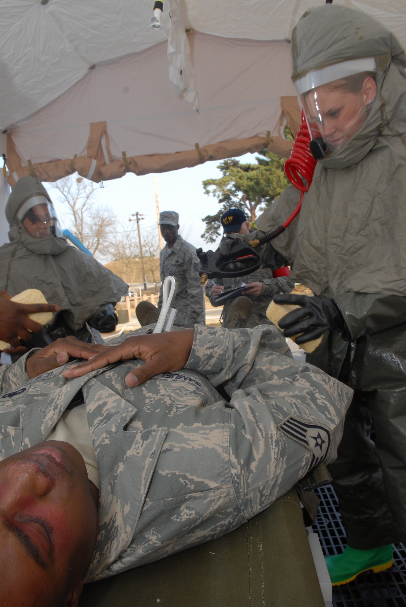 KUNSAN AIR BASE, Republic of Korea -- Staff Sgt. Kimmie Samuel, 8th Air Craft Maintenance Squadron, is decontaminated by Senior Airman Wendy Lloyd before being treated at the 8th Medical Group during a All Hazards Response Training scenario at Kunsan Air Base, Republic of Korea, Dec. 9, 2008. AHRT is a weeklong training that tests the all the base agencies on their response and capabilities during  crisis scenarios.(U.S. Air Force photo by: Senior Airman Angela Ruiz)(Released 8th Fighter Wing Public Affairs,)