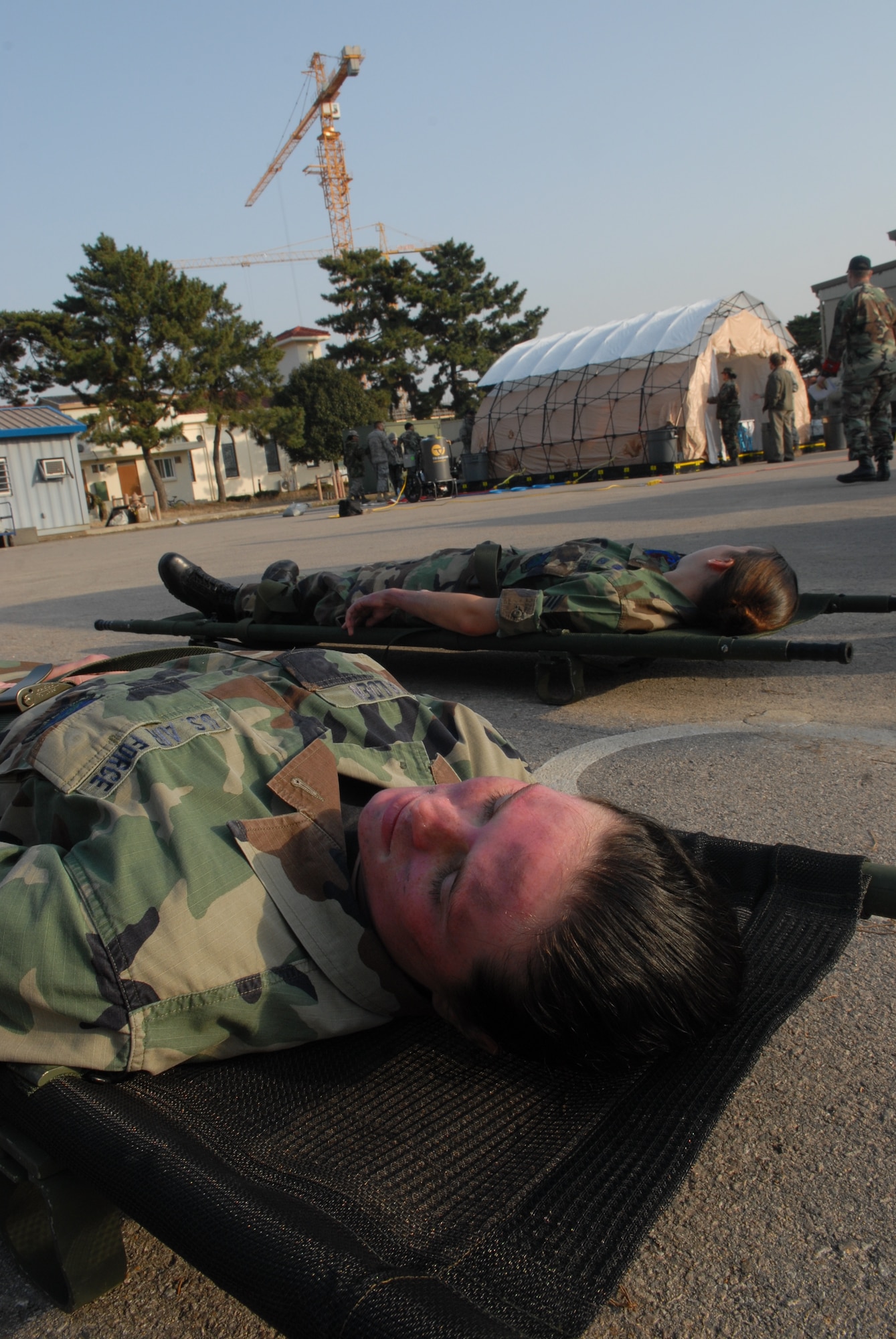 KUNSAN AIR BASE, Republic of Korea – Senior Airman Corrie Walden, 8th Logistics Readiness Squadron and Senior Airman Clair Eisele, 8th Civil Engineer Squadron, lay in stretchers waiting for the 8th Medical Group to treat them during a All Hazards Response Training scenario at Kunsan Air Base, Republic of Korea, Dec. 9, 2008. AHRT is a weeklong training that tests the all the base agencies on their response and capabilities during crisis scenarios.(U.S. Air Force photo by: Senior Airman Angela Ruiz)